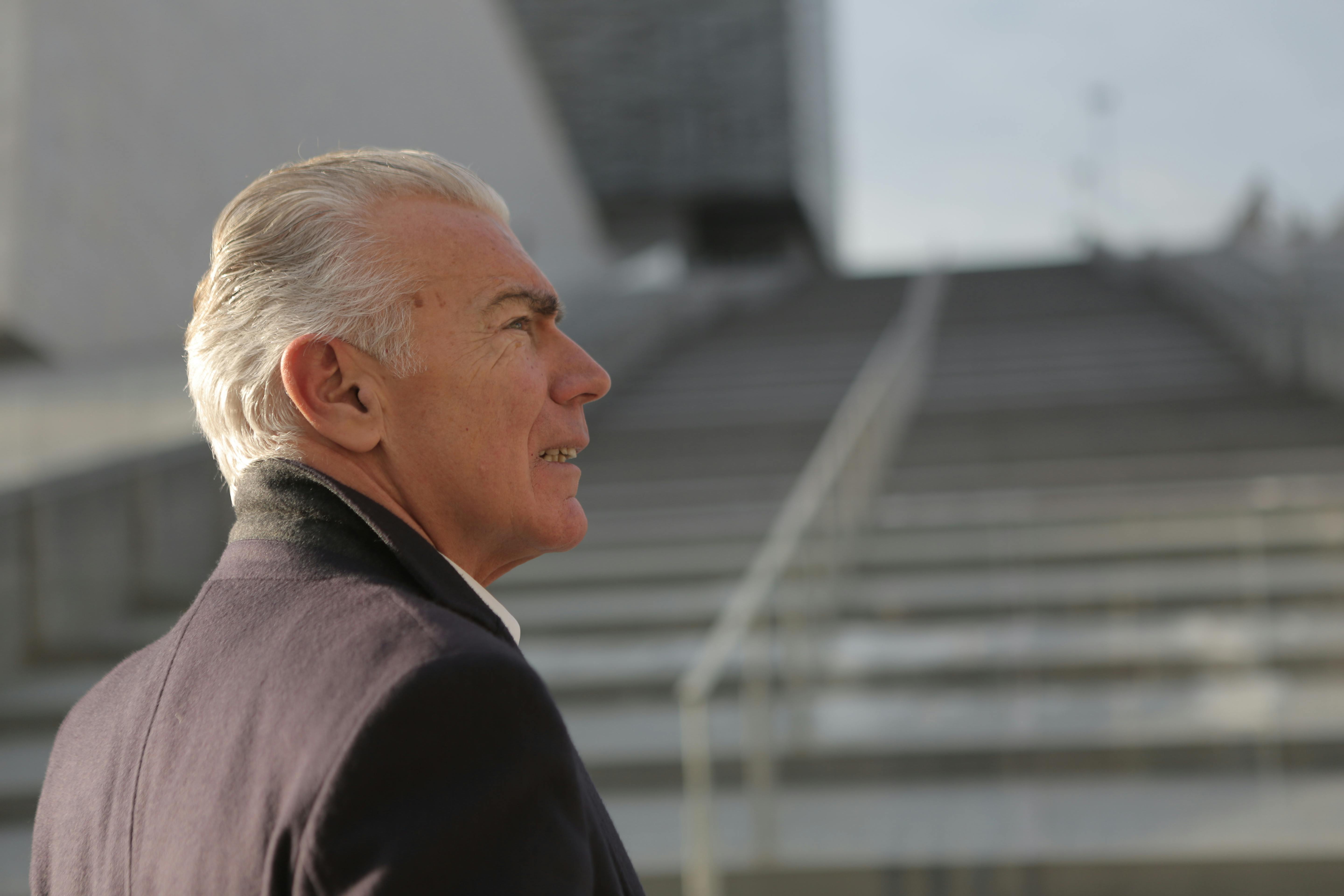 Anciano de pie cerca de una escalera | Fuente: Pexels