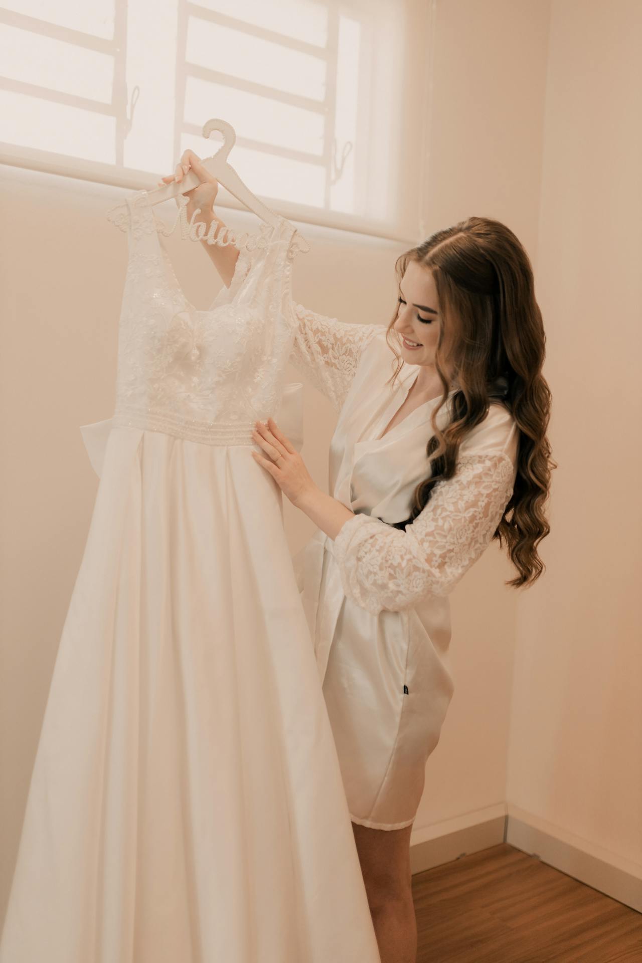 Una mujer admirando su vestido de novia | Fuente: Pexels