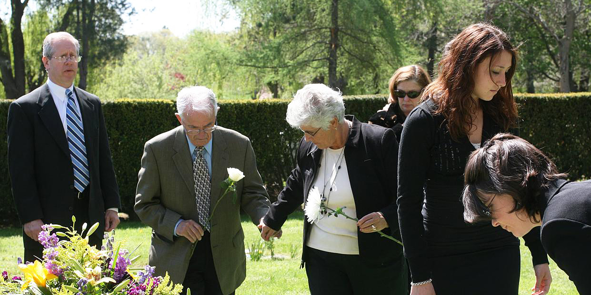 Gente de pie cerca de una tumba | Fuente: Flickr