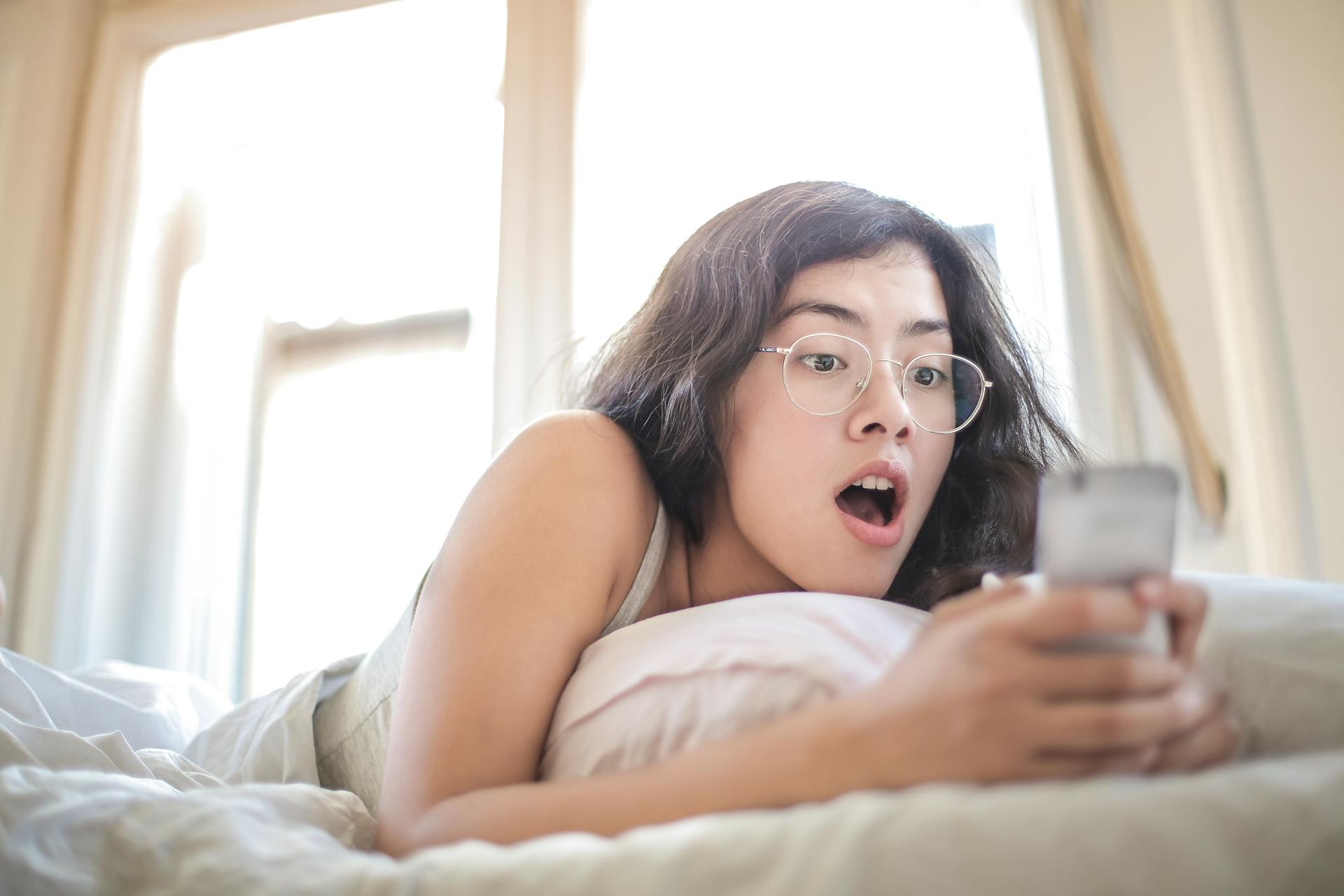 Una mujer mirando atónita su teléfono | Fuente: Pexels