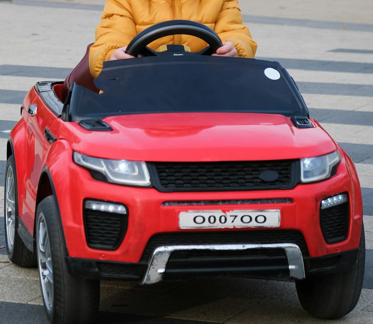 Un niño montado en un coche de juguete rojo | Fuente: Pexels
