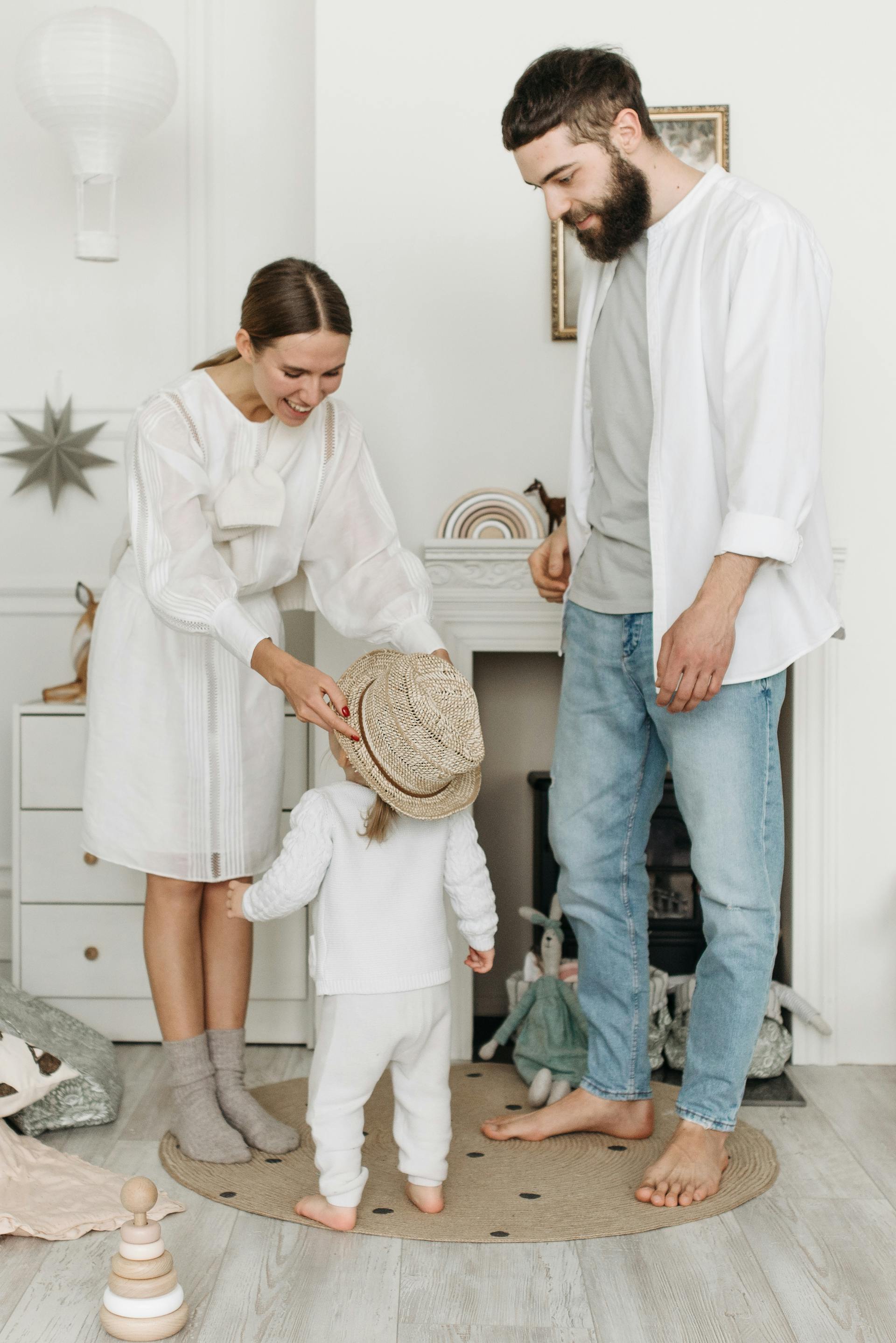 Un hombre observa cómo una mujer pone un sombrero a una niña | Fuente: Pexels