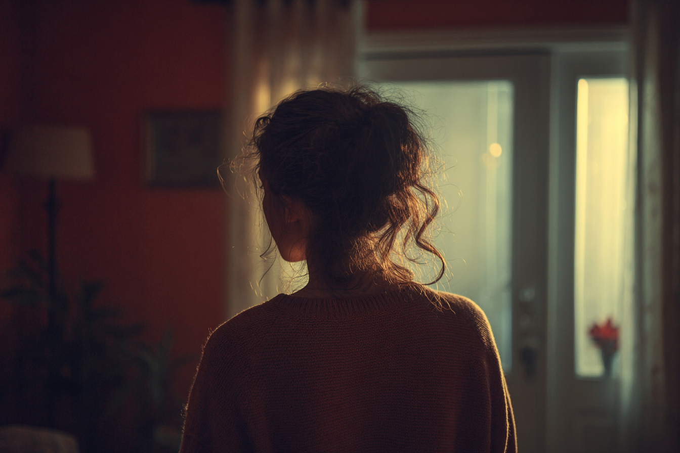 Una joven junto a una ventana | Fuente: Midjourney