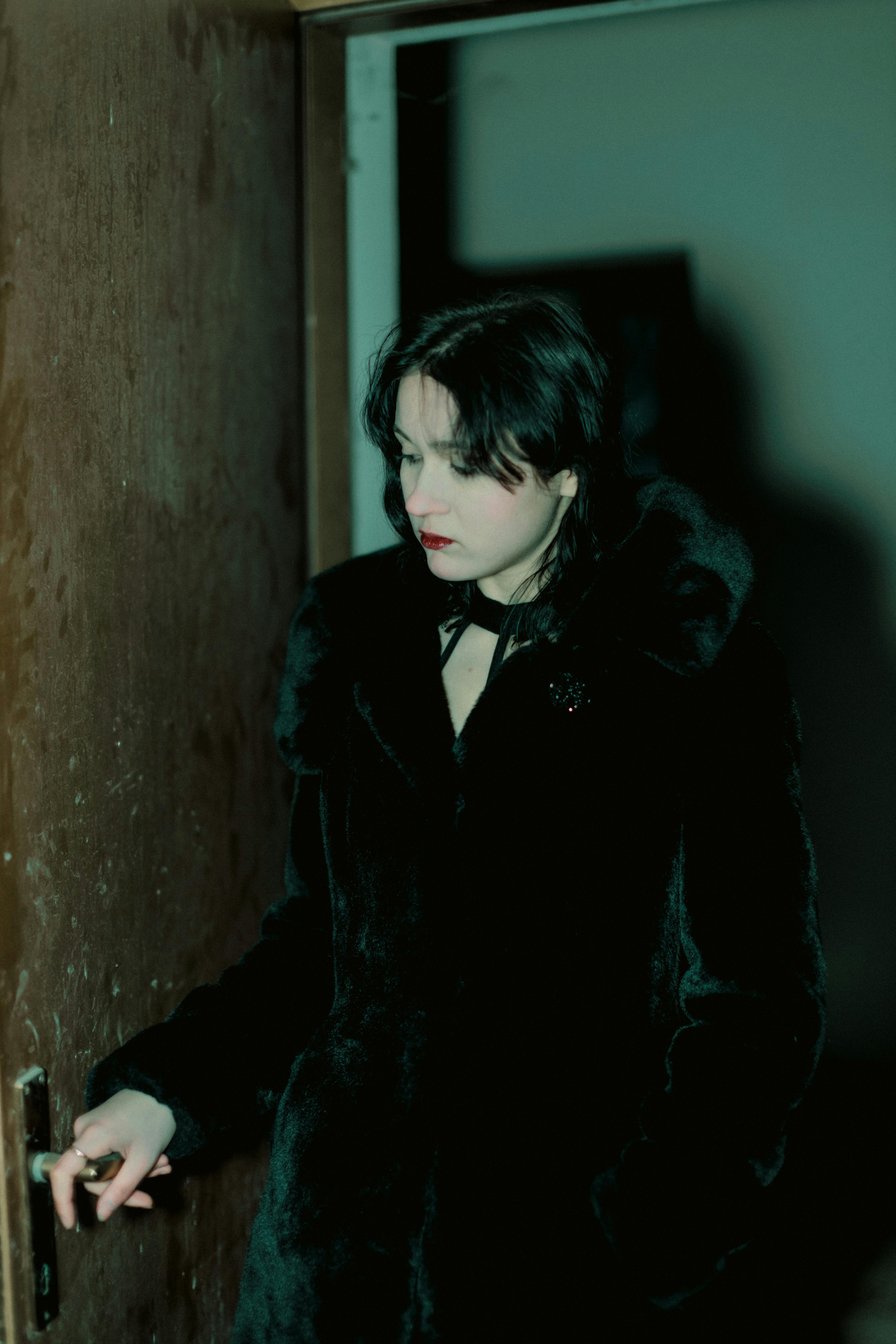 Mujer sujetando el pomo de una puerta | Fuente: Pexels