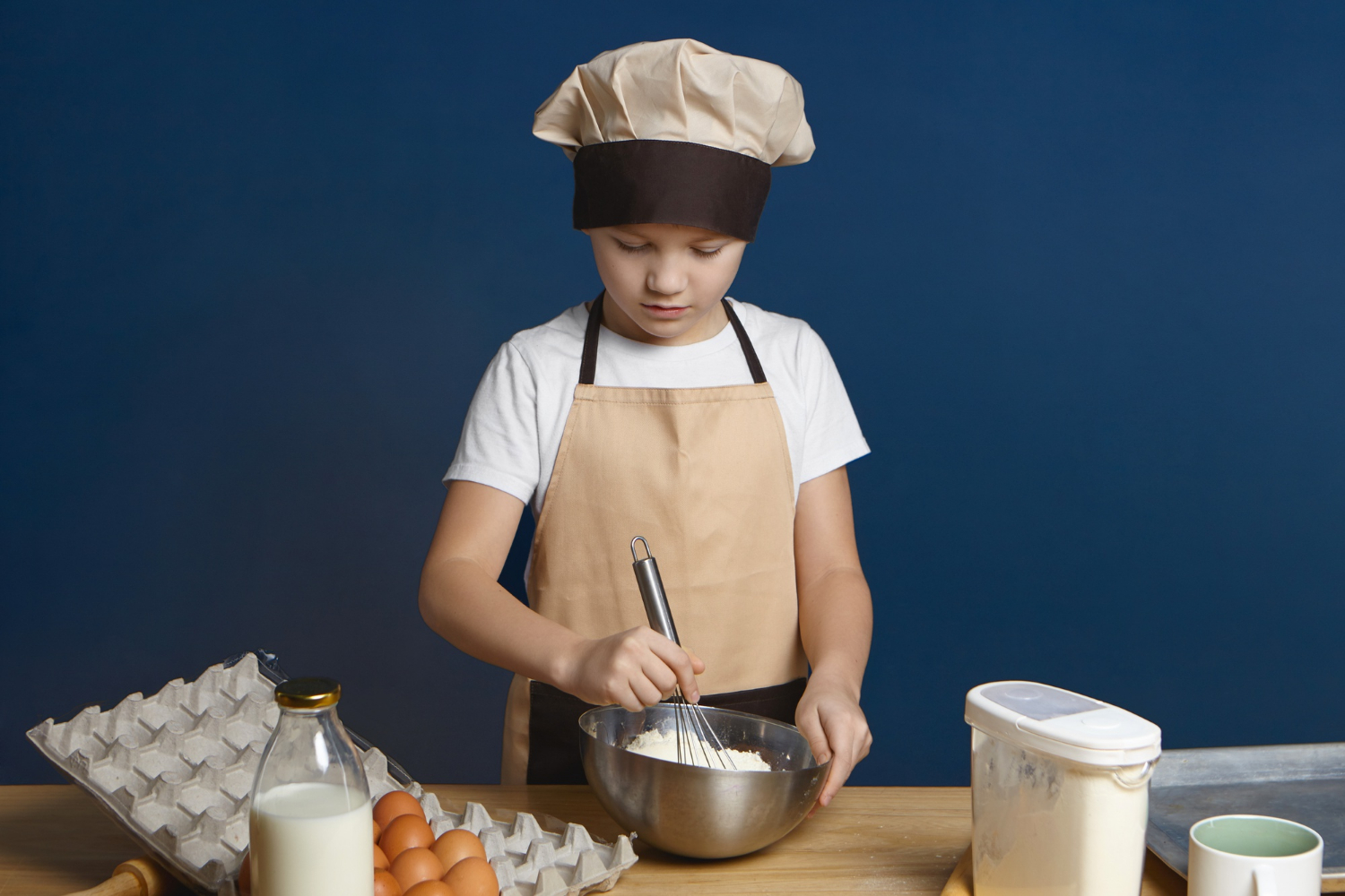 Un niño ocupado horneando | Fuente: Freepik
