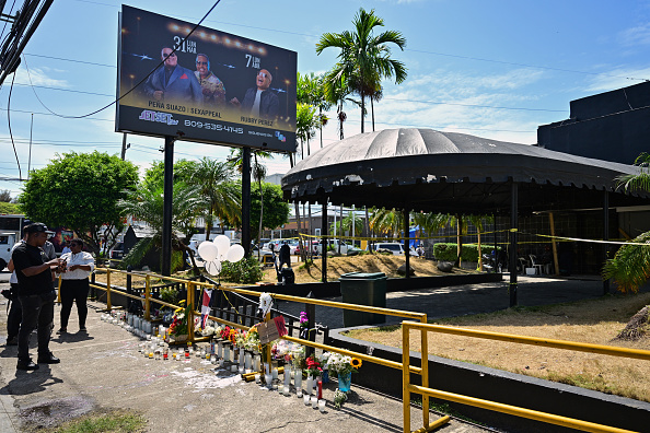 Personas observan las flores y velas colocadas en homenaje a las víctimas frente a la discoteca Jet Set en Santo Domingo, el 11 de abril de 2025 | Fuente: Getty Images