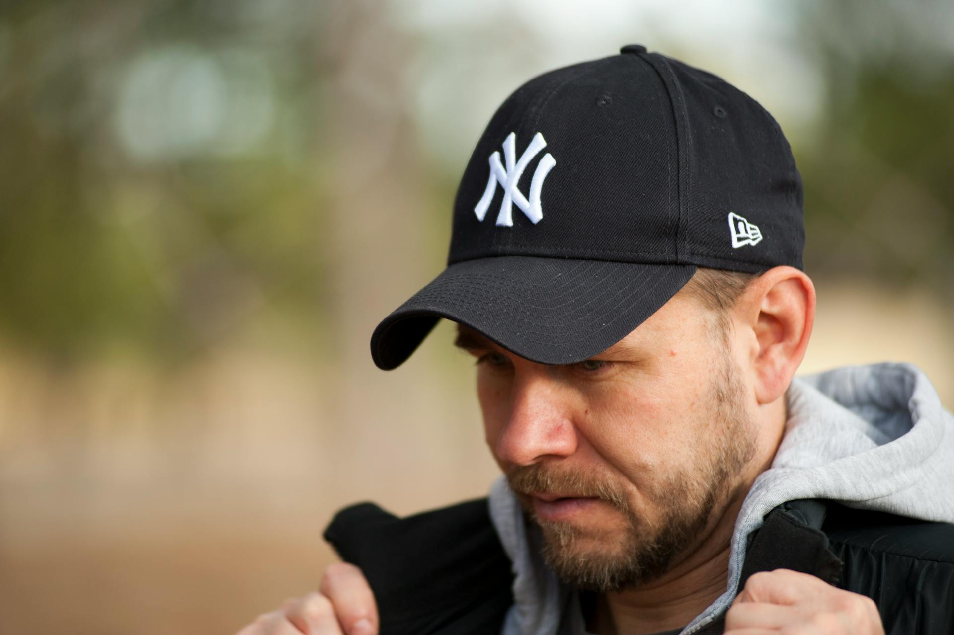 Hombre con sudadera con capucha y gorra de béisbol | Fuente: Pexels