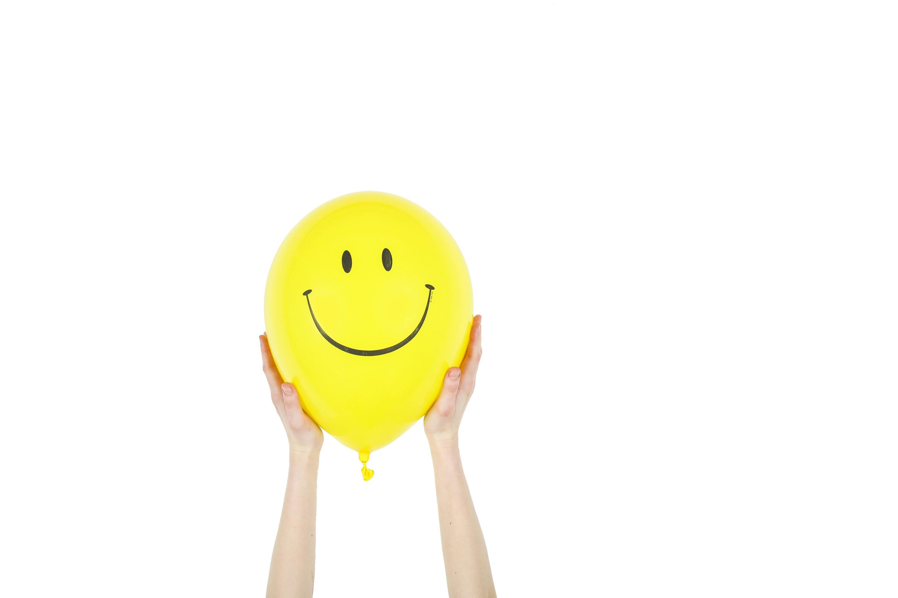 Alguien sujetando un gran globo amarillo | Fuente: Pexels