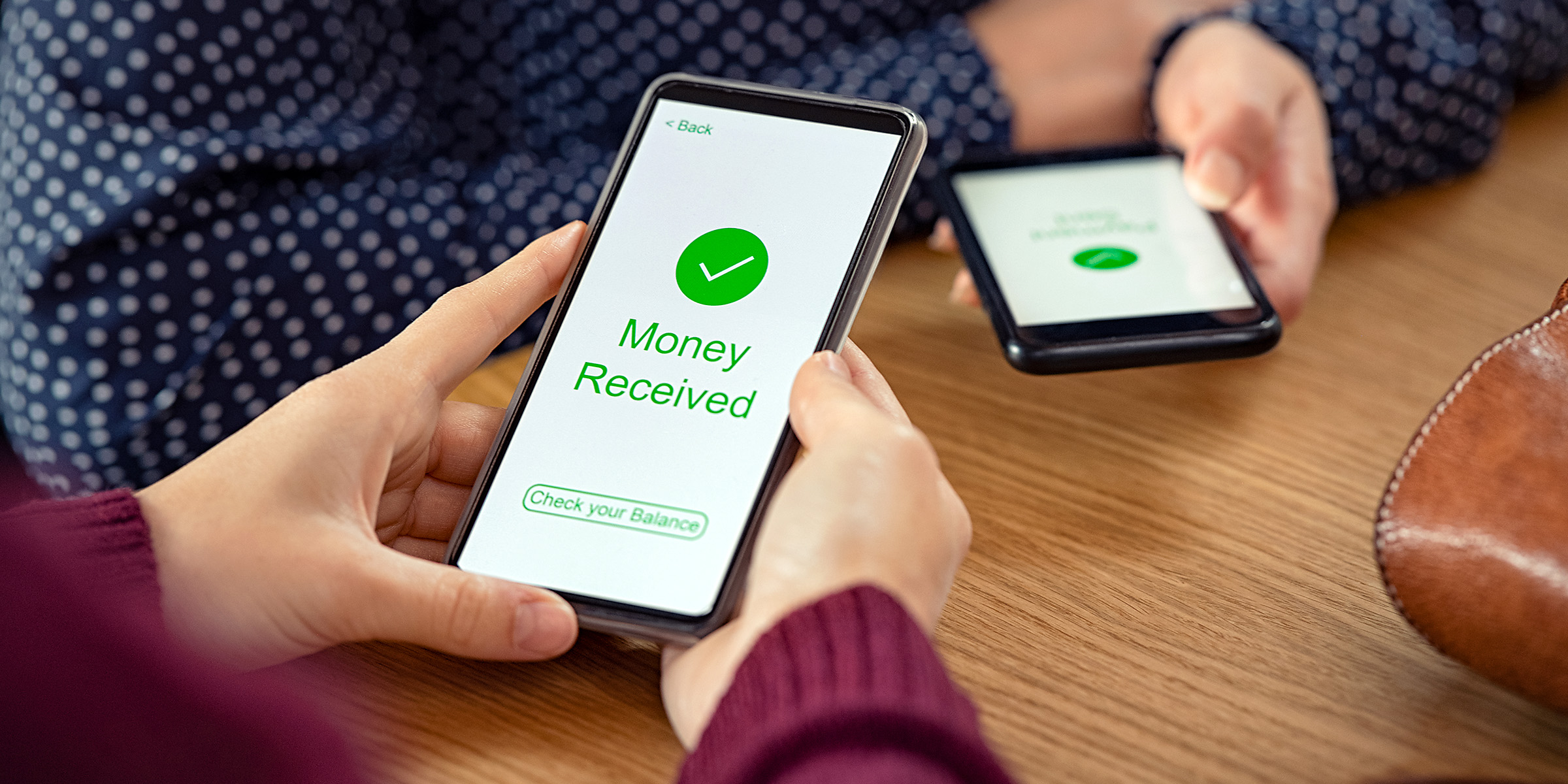 Una persona sostiene un teléfono que muestra una pantalla de confirmación de "Dinero recibido" | Fuente: Shutterstock