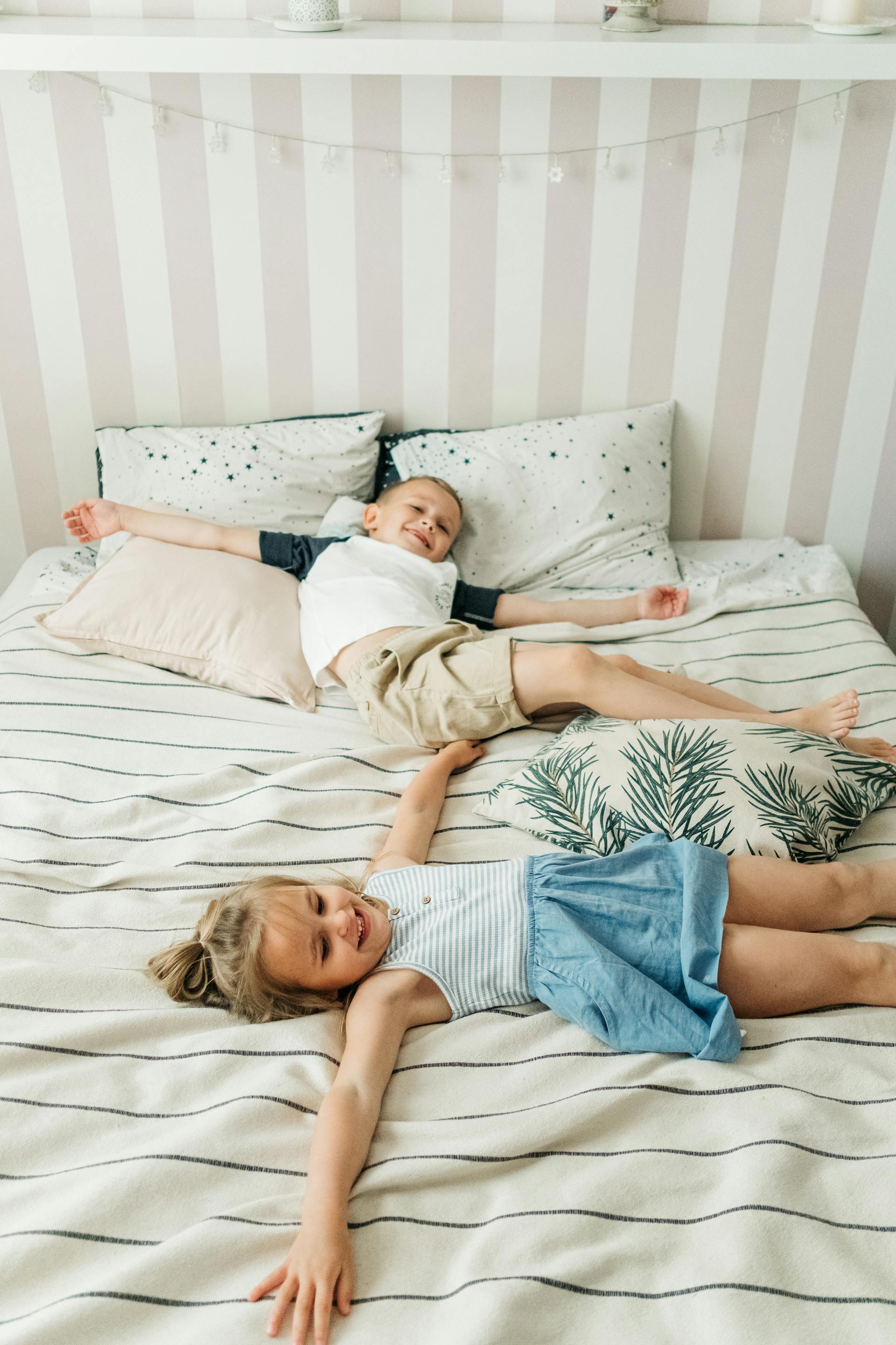 Niños tumbados en la cama | Fuente: Pexels