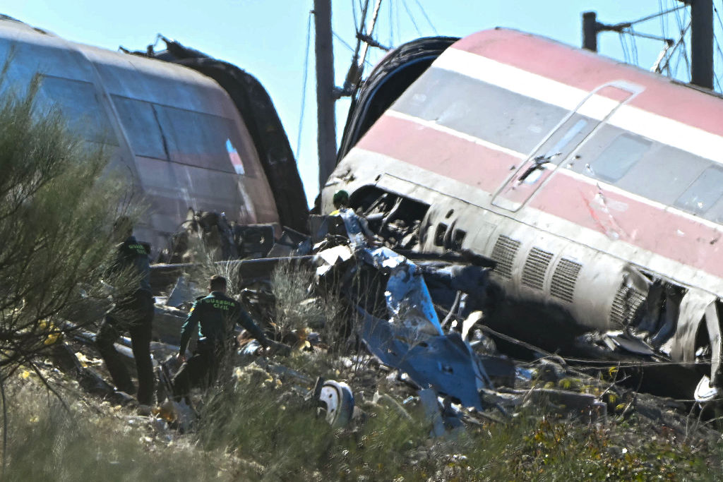 Agentes de la Guardia Civil se encuentran entre los restos de una colisión ferroviaria entre un tren de alta velocidad AVE de Renfe y un tren de Iryo, ocurrida a unos 150 km al sur de Madrid, entre Urda y Los Yébenes (provincia de Toledo), el 28 de octubre de 2026. | Fuente: Getty Images