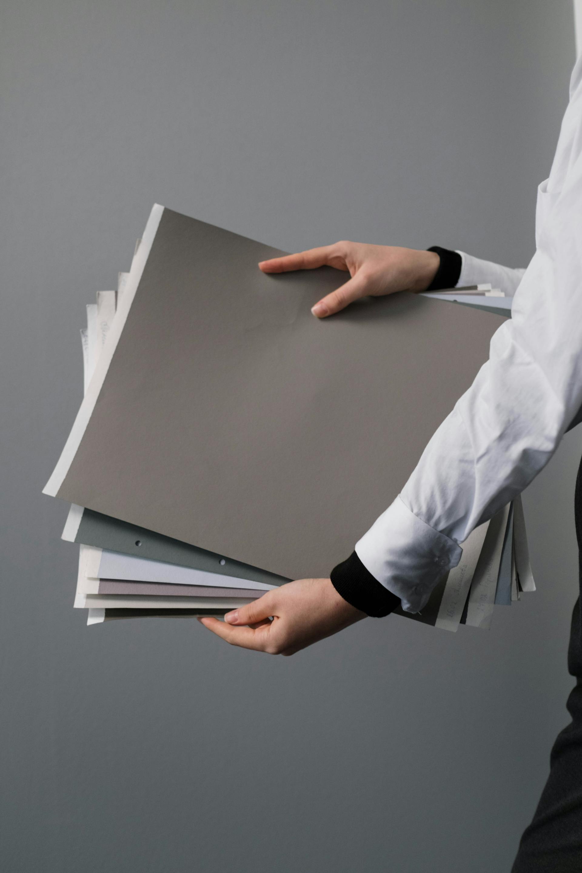 Una persona sujetando papeles y carpetas | Fuente: Pexels