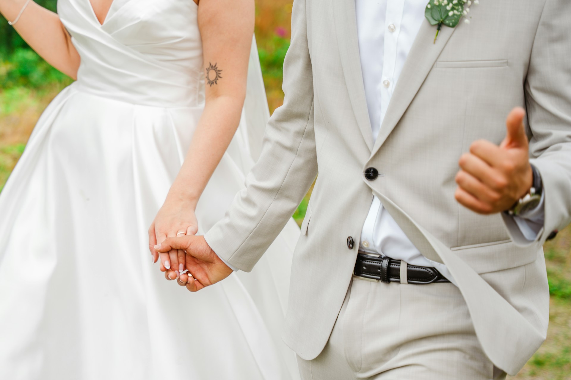 Una novia y un novio cogidos de la mano y caminando juntos | Fuente: Unsplash