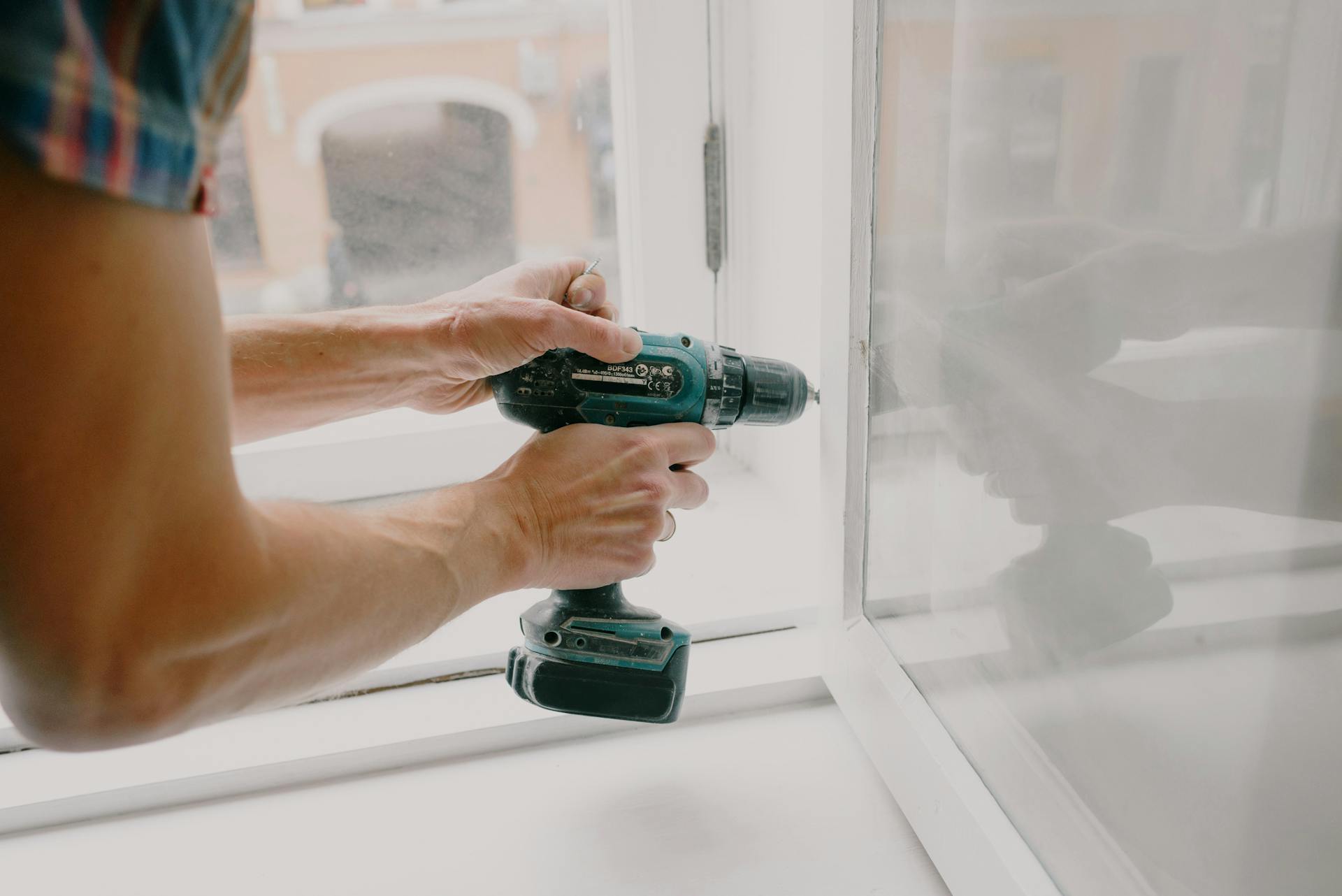 Primer plano de un hombre arreglando una ventana | Fuente: Pexels