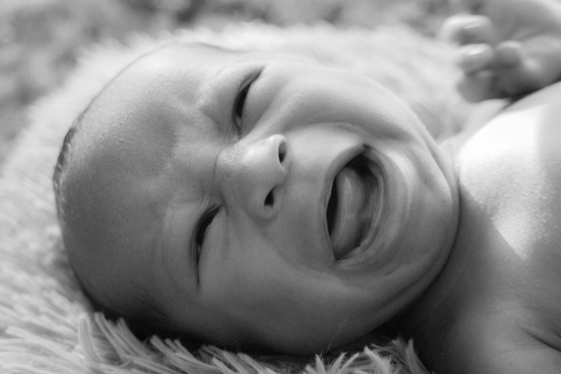 Foto en escala de grises de un bebé llorando | Fuente: Pexels