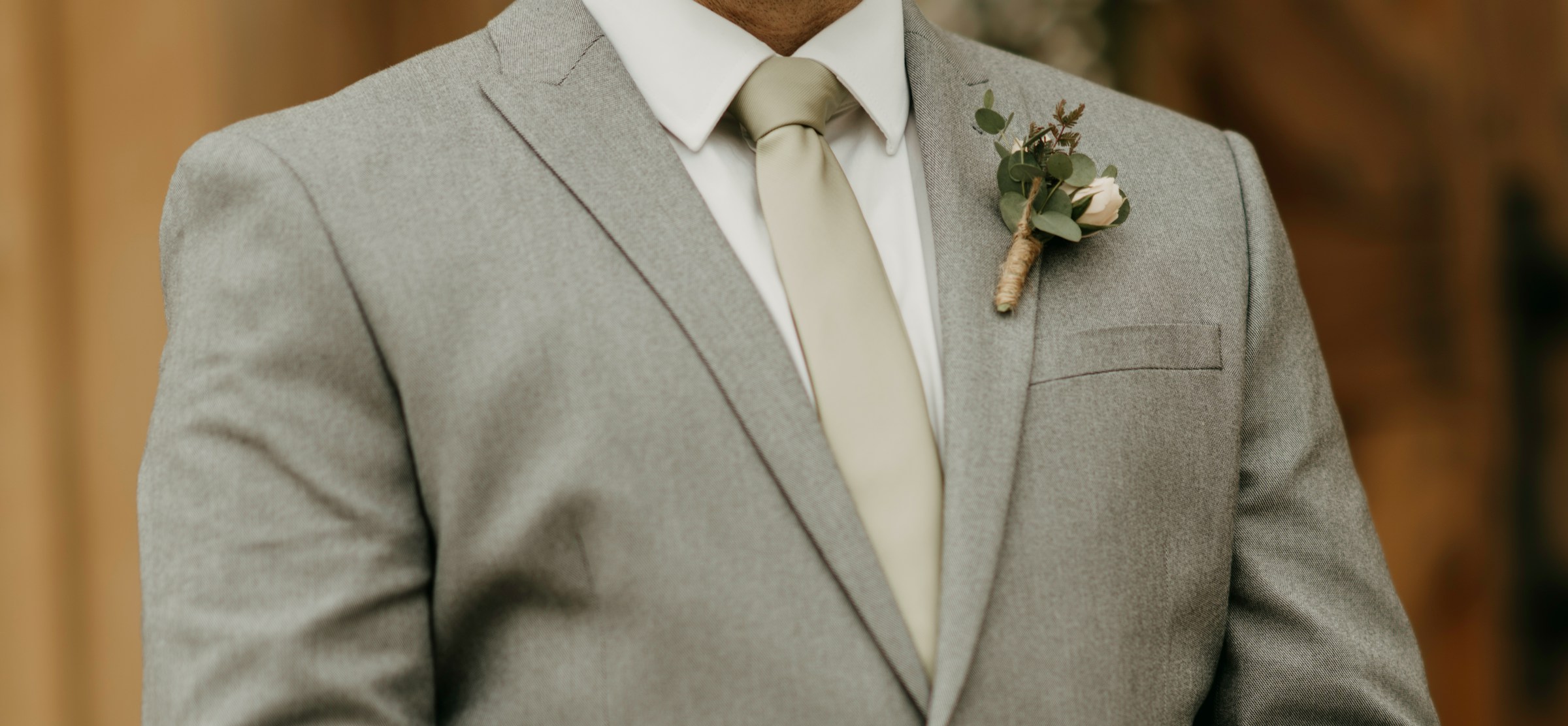 Un hombre con traje gris y un boutonniere en la solapa | Fuente: Unsplash
