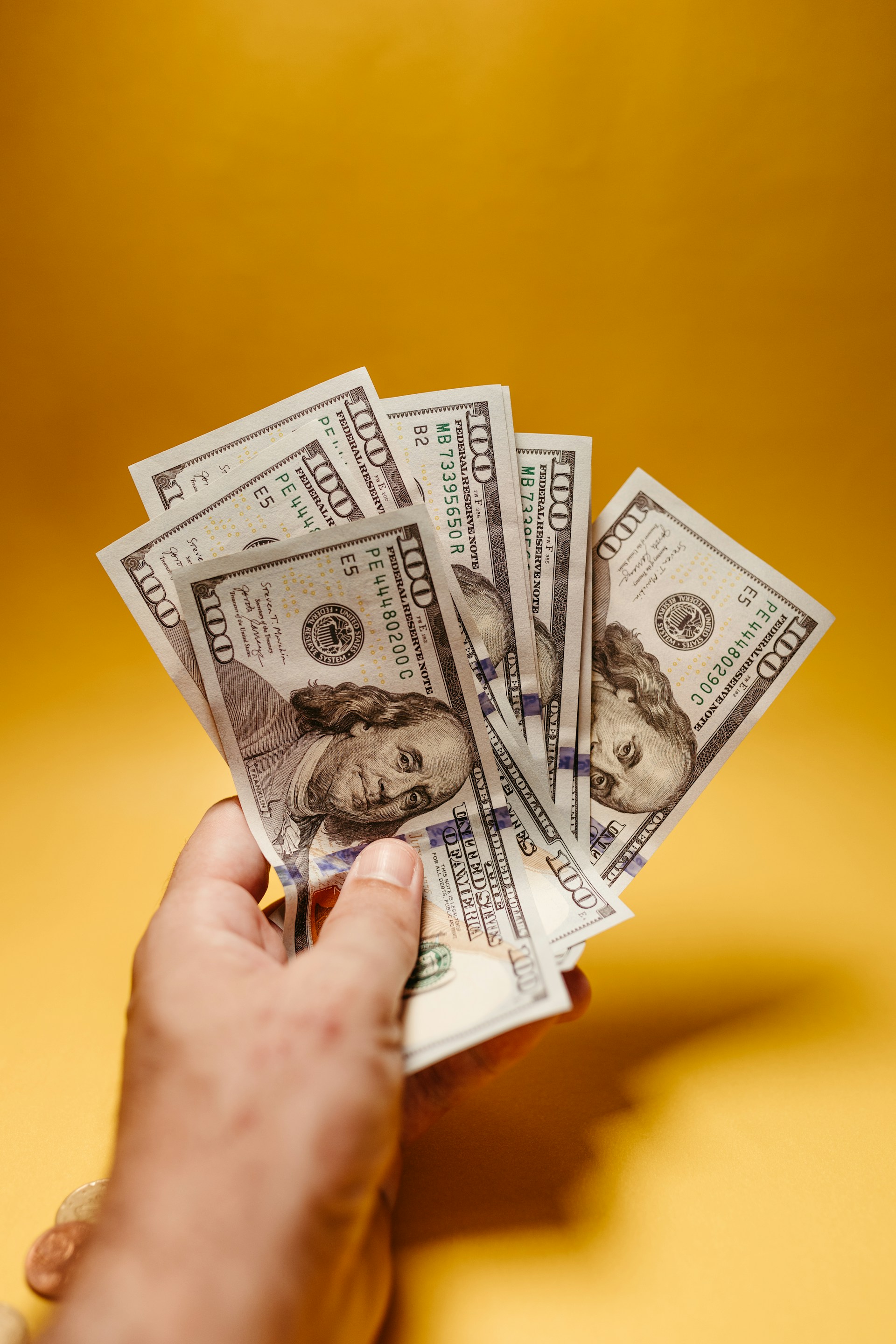 Un hombre con billetes de cien dólares | Fuente: Unsplash