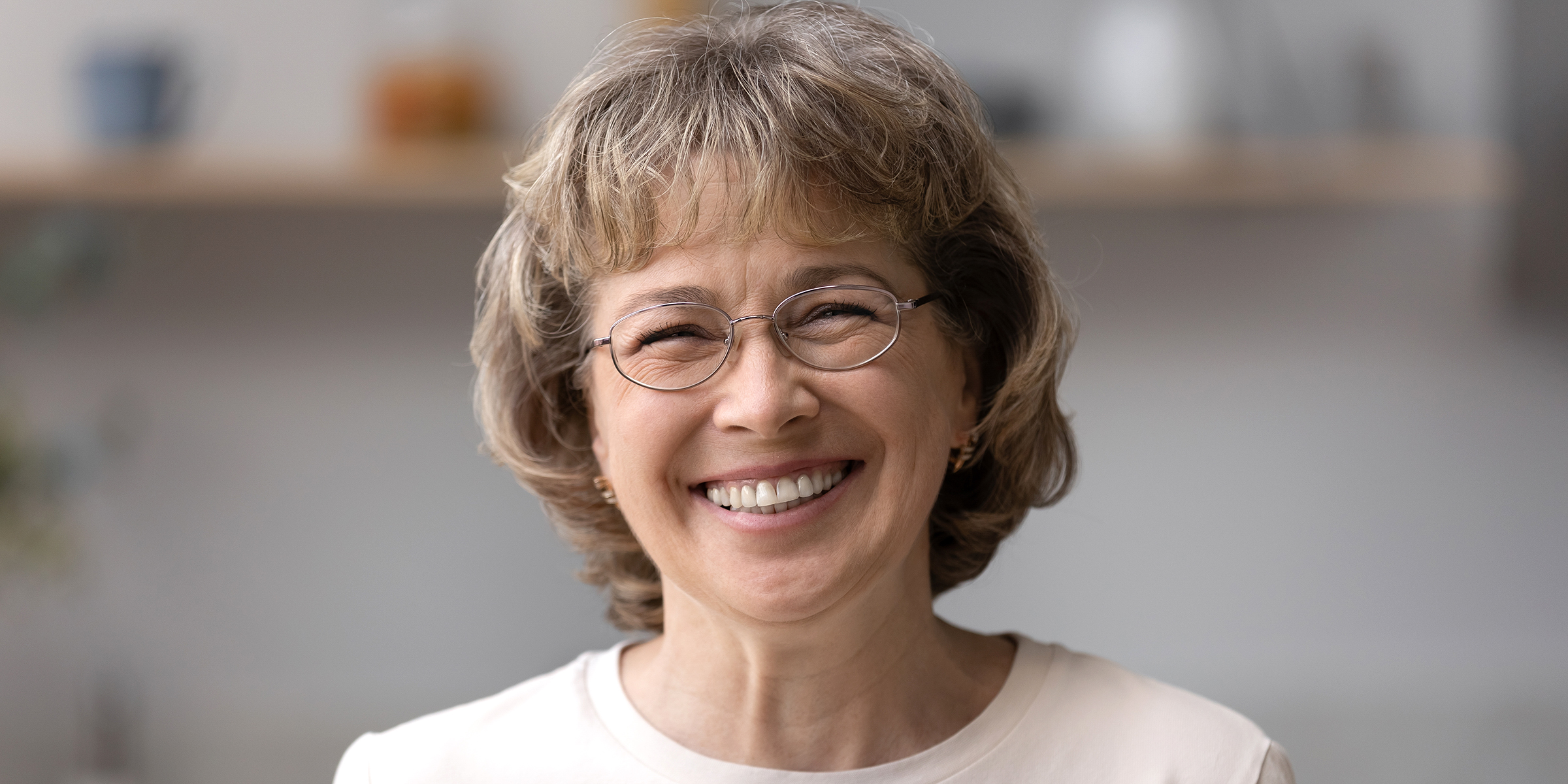 Una mujer sonriente con gafas | Fuente: Shutterstock