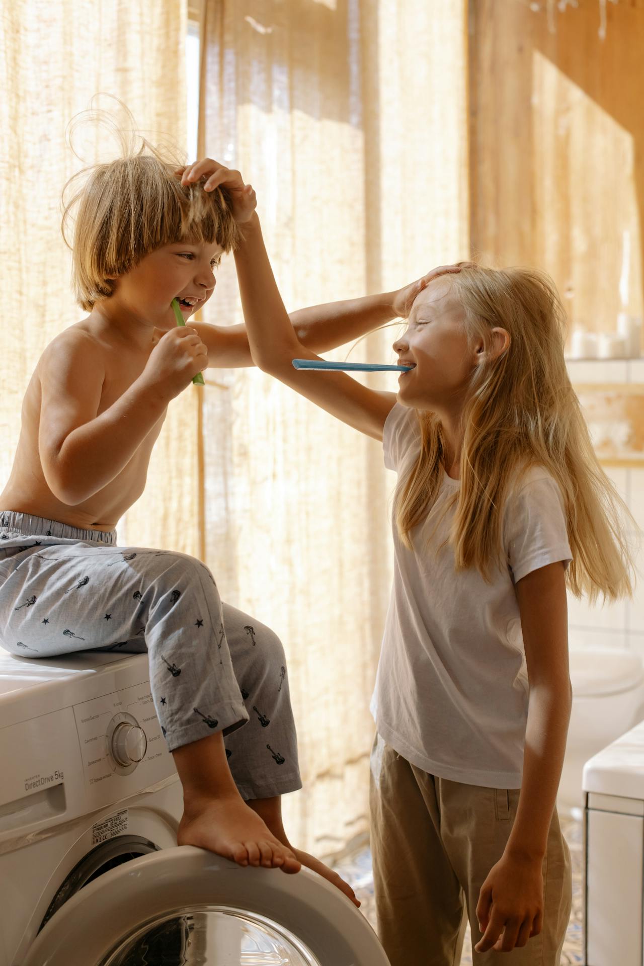 Hermanos cepillándose los dientes | Fuente: Pexels