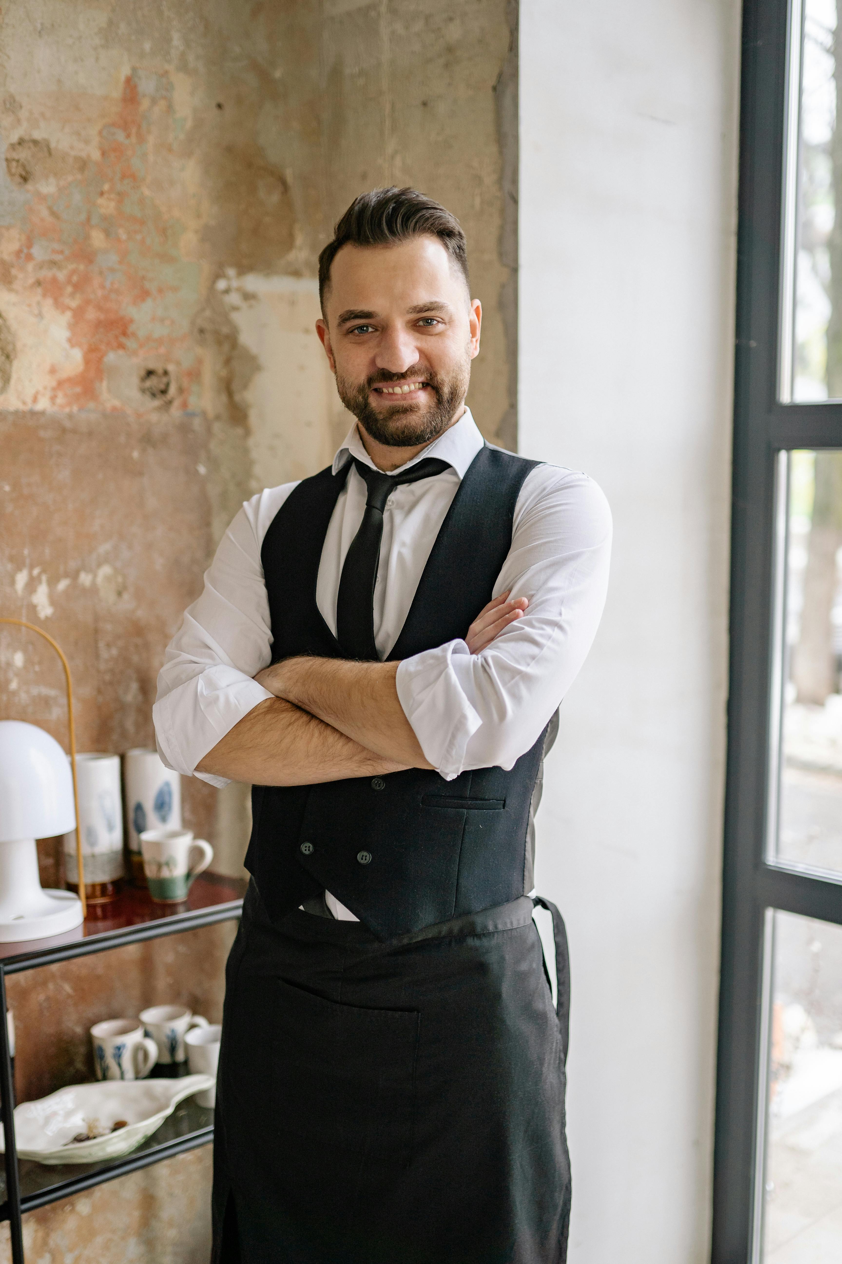 Un camarero sonriente | Fuente: Pexels