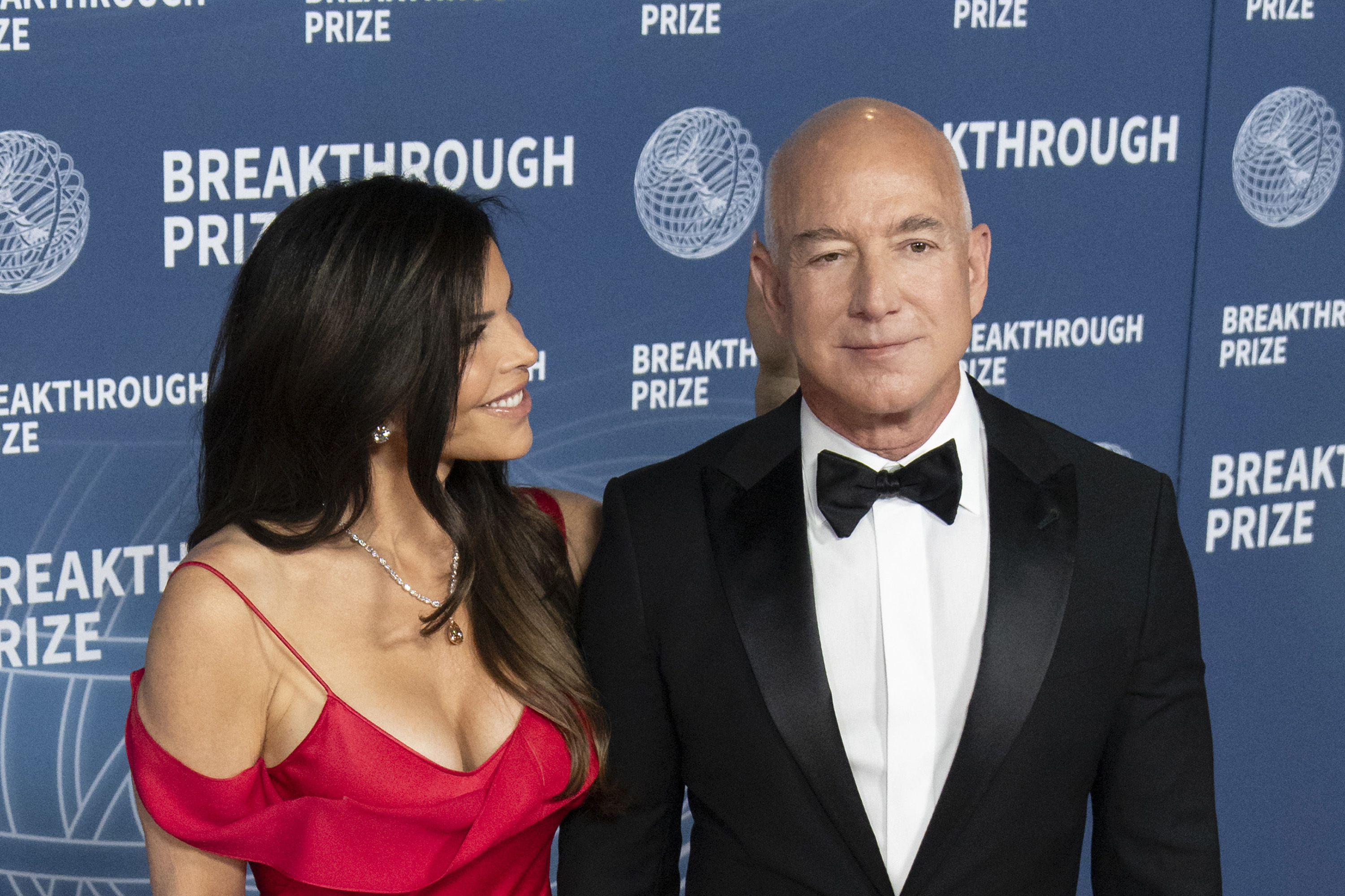 Lauren Sanchez mira a Jeff Bezos mientras posan en la alfombra de llegadas de la ceremonia de entrega del Premio Breakthrough 2025, el 5 de abril de 2025, en Santa Mónica, California | Fuente: Getty Images