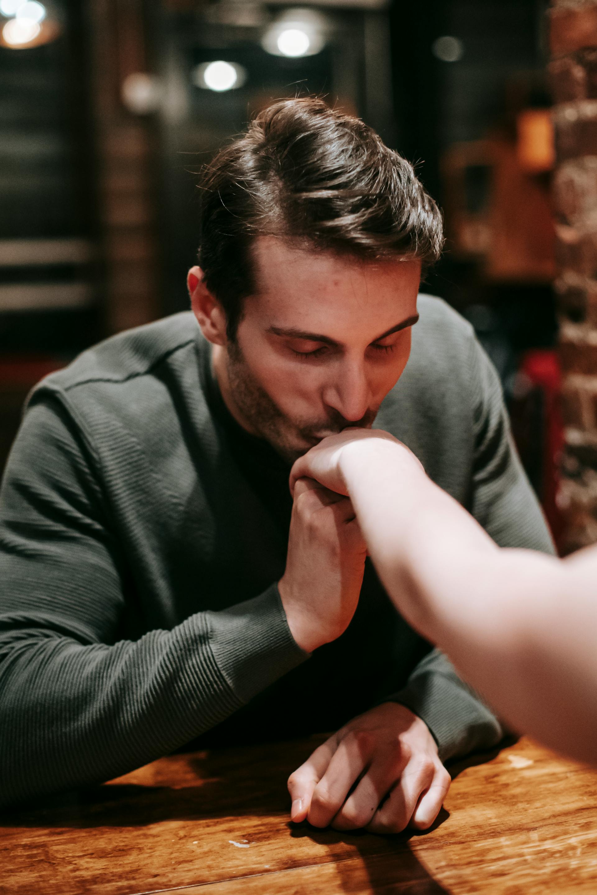 Un hombre besando la mano de una mujer | Fuente: Pexels