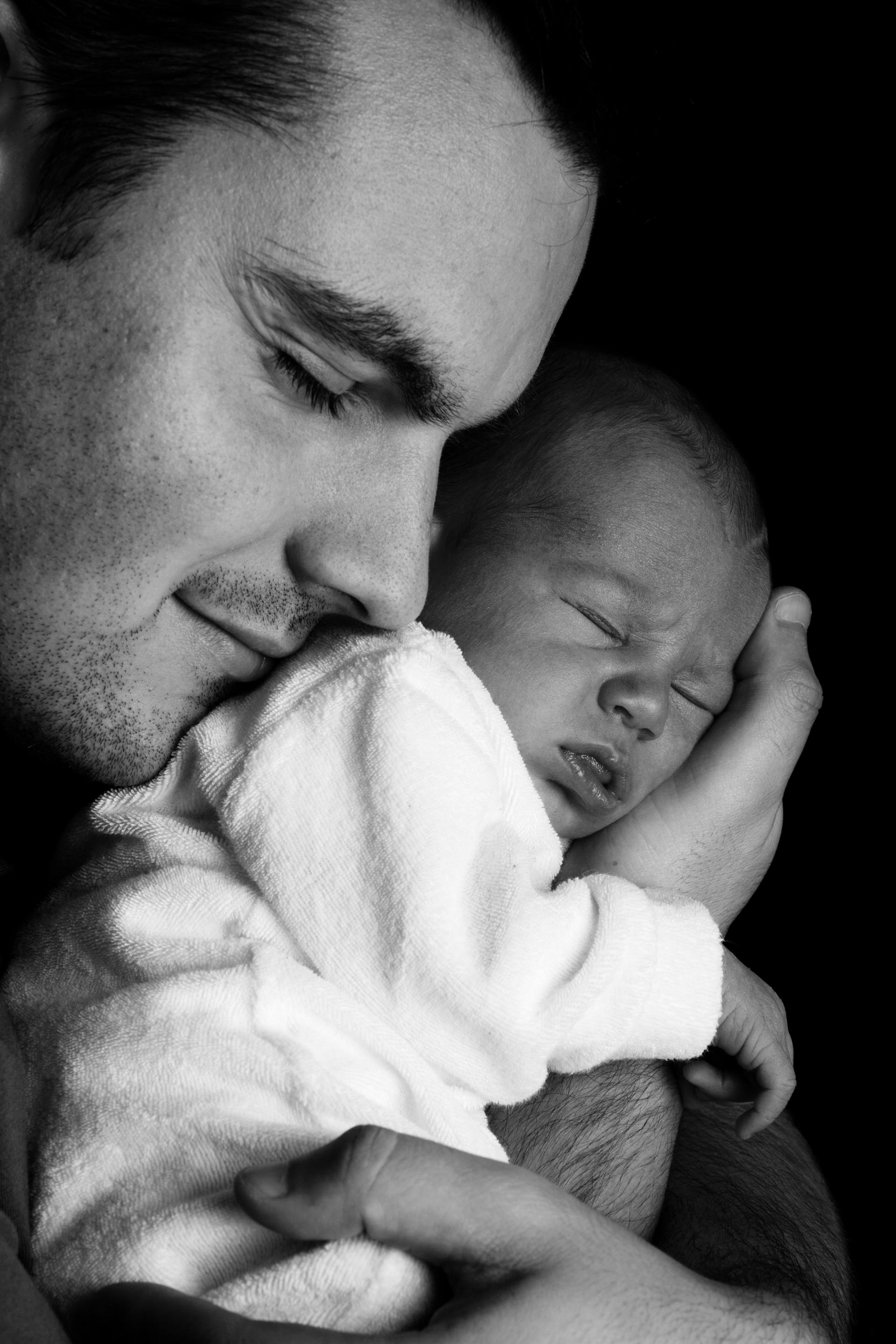 Foto en escala de grises de un hombre con un bebé recién nacido | Fuente: Pexels