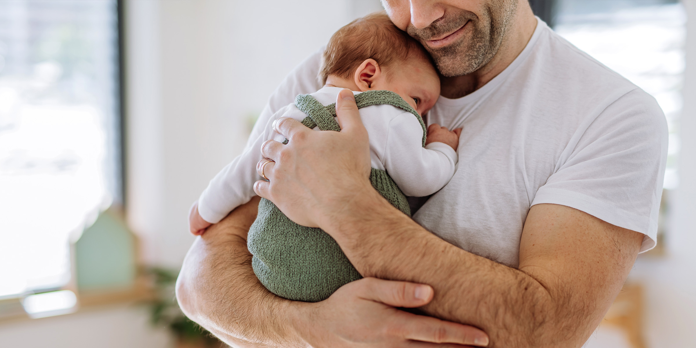 Un hombre con un bebé en brazos | Fuente: Shutterstock
