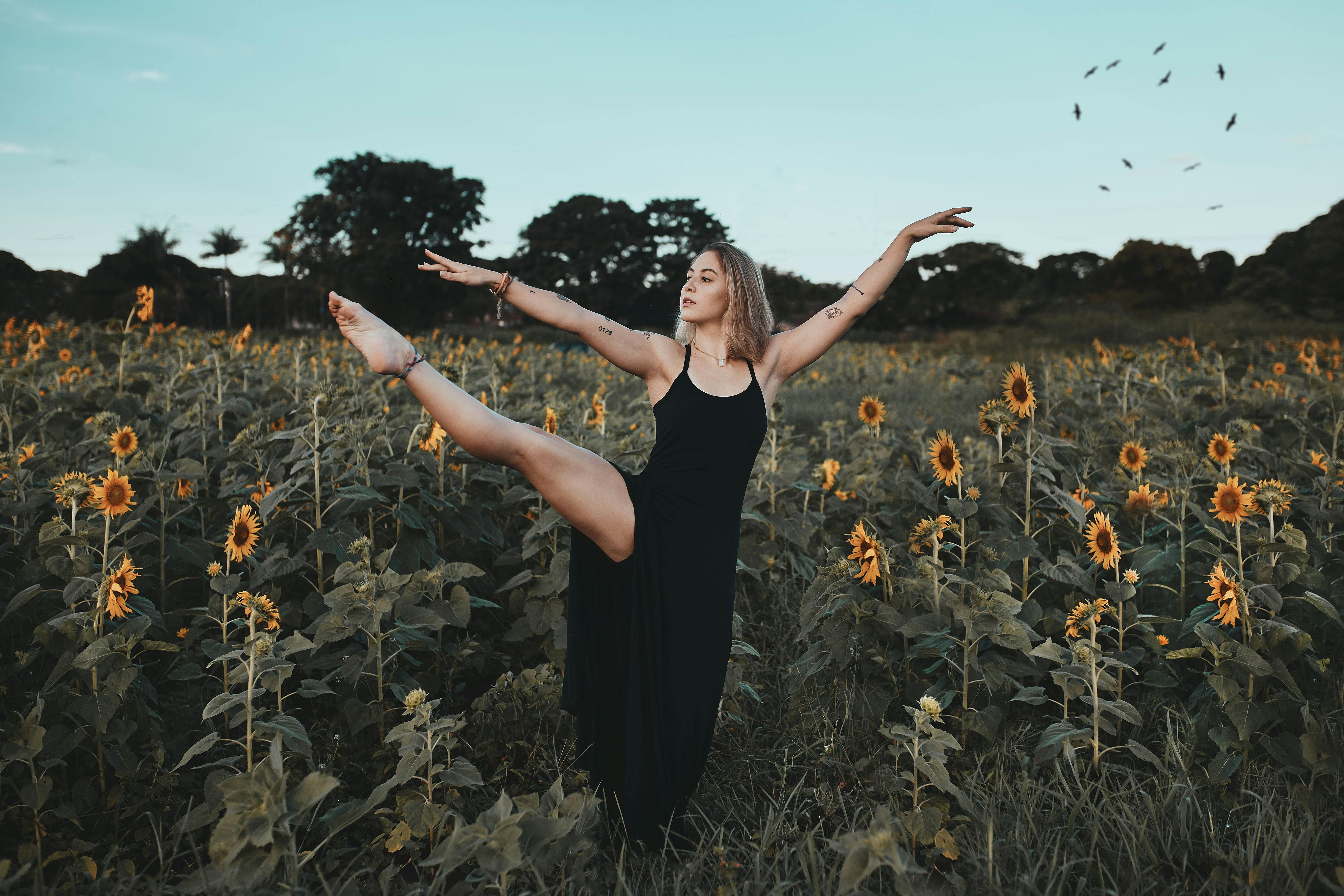 Una mujer bailando entre flores | Fuente: Pexels