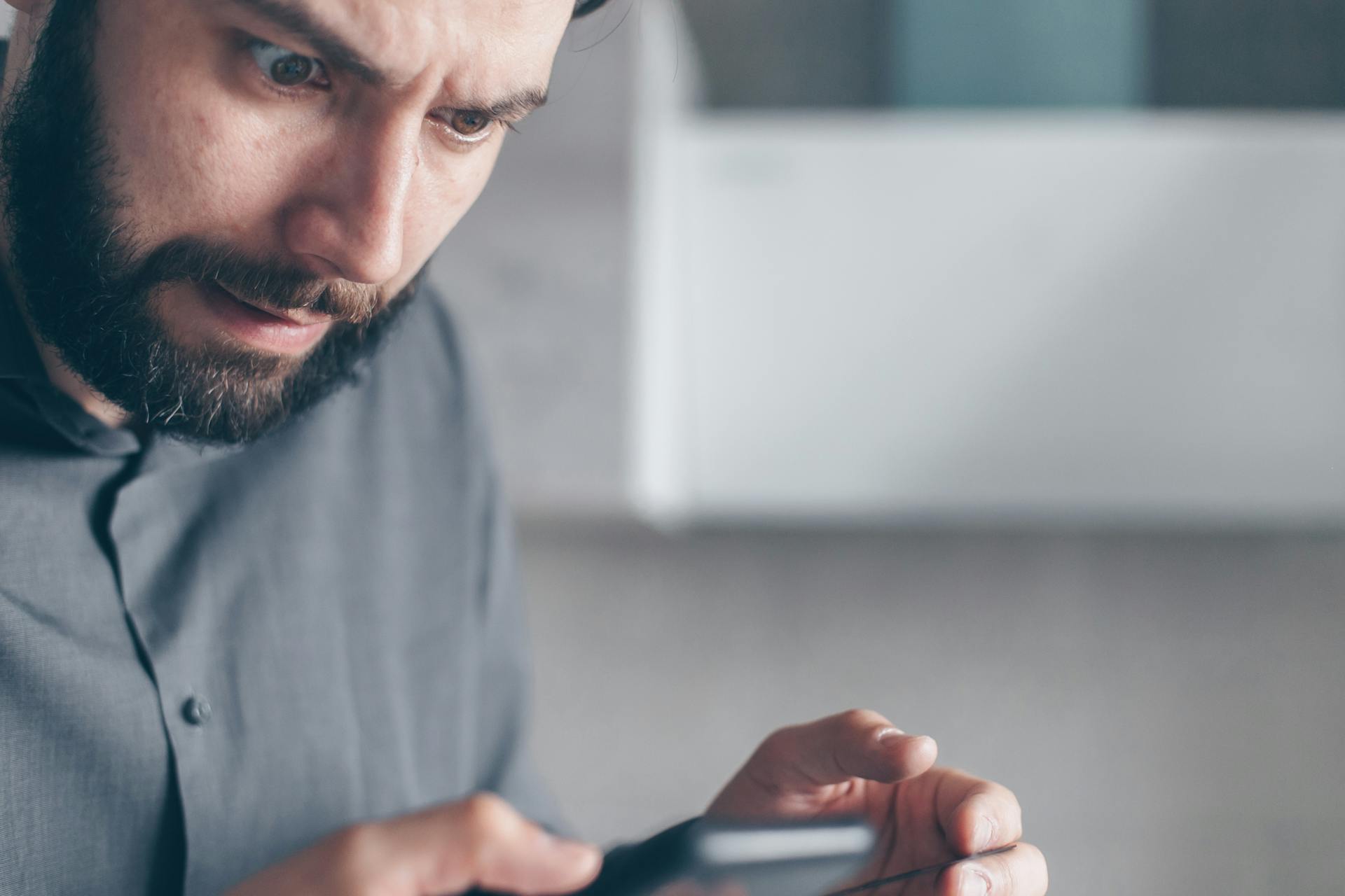 Un hombre mirando atónito su teléfono | Fuente: Pexels