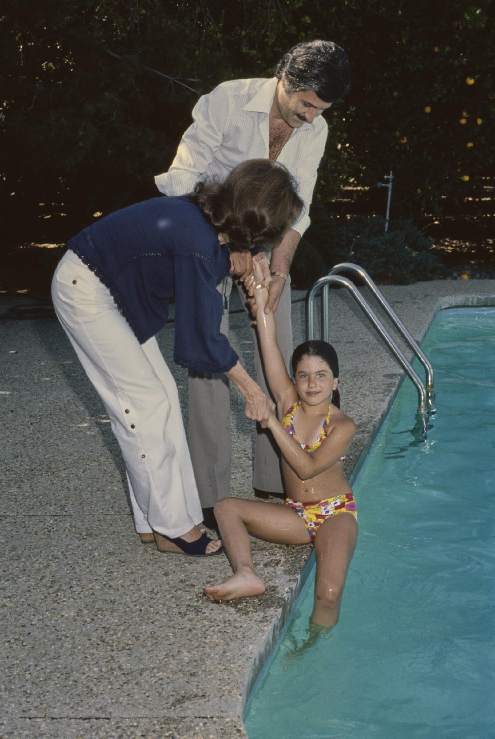 La niña y sus padres en la casa familiar de Sherman Oaks, en Los Ángeles, California, en 1975 | Fuente: Getty Images
