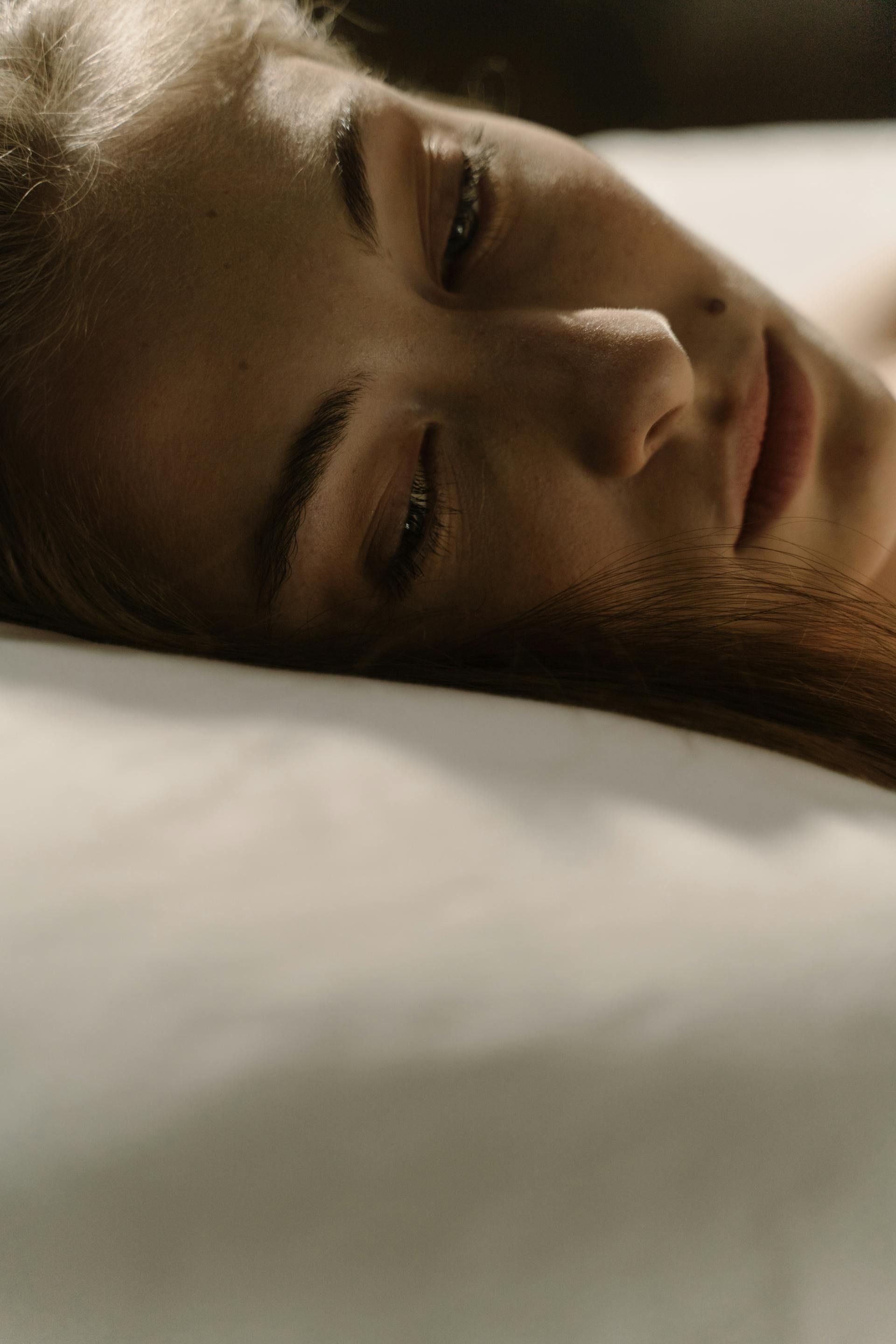 Primer plano de una mujer despierta en la cama | Fuente: Pexels