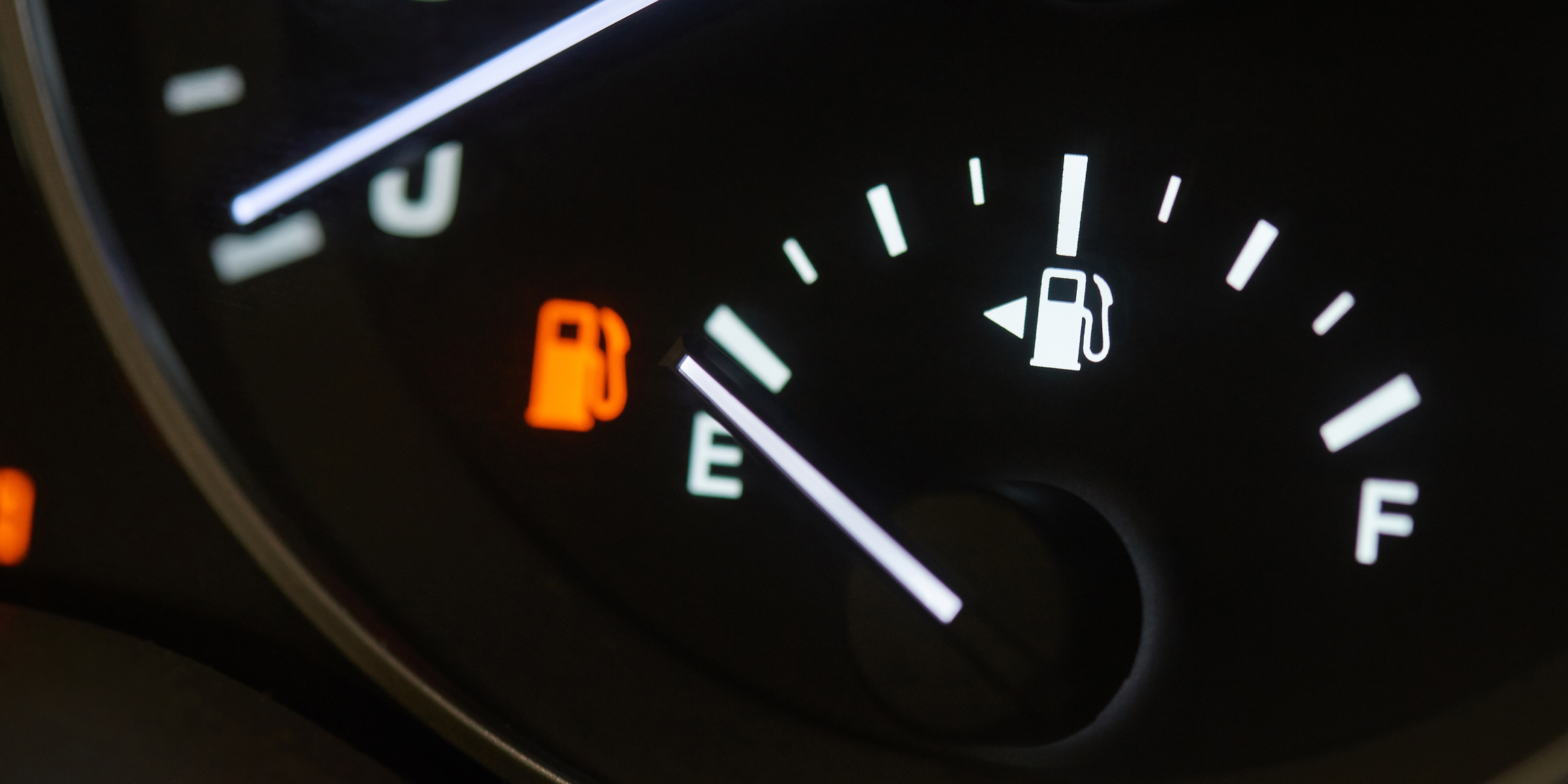 Indicador de combustible de automóvil en vacío con luz de aviso de bajo nivel de combustible encendida | Fuente: Shutterstock
