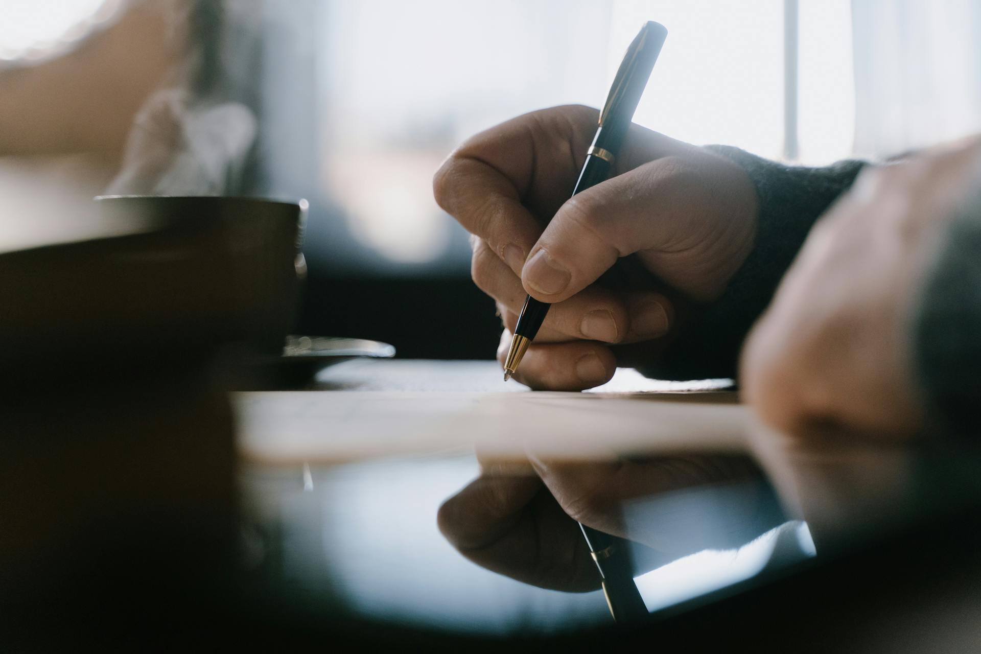 Un hombre escribiendo con un bolígrafo | Fuente: Pexels
