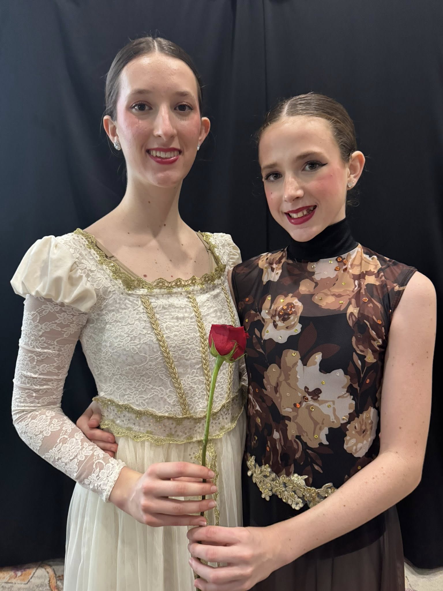 Malaya y Surya Hammond sosteniendo una rosa y sonriendo ante un fondo oscuro hacia mayo de 2025. De un post fechado el 25 de junio de 2025. | Fuente: Facebook/elizabeth.m.hammond