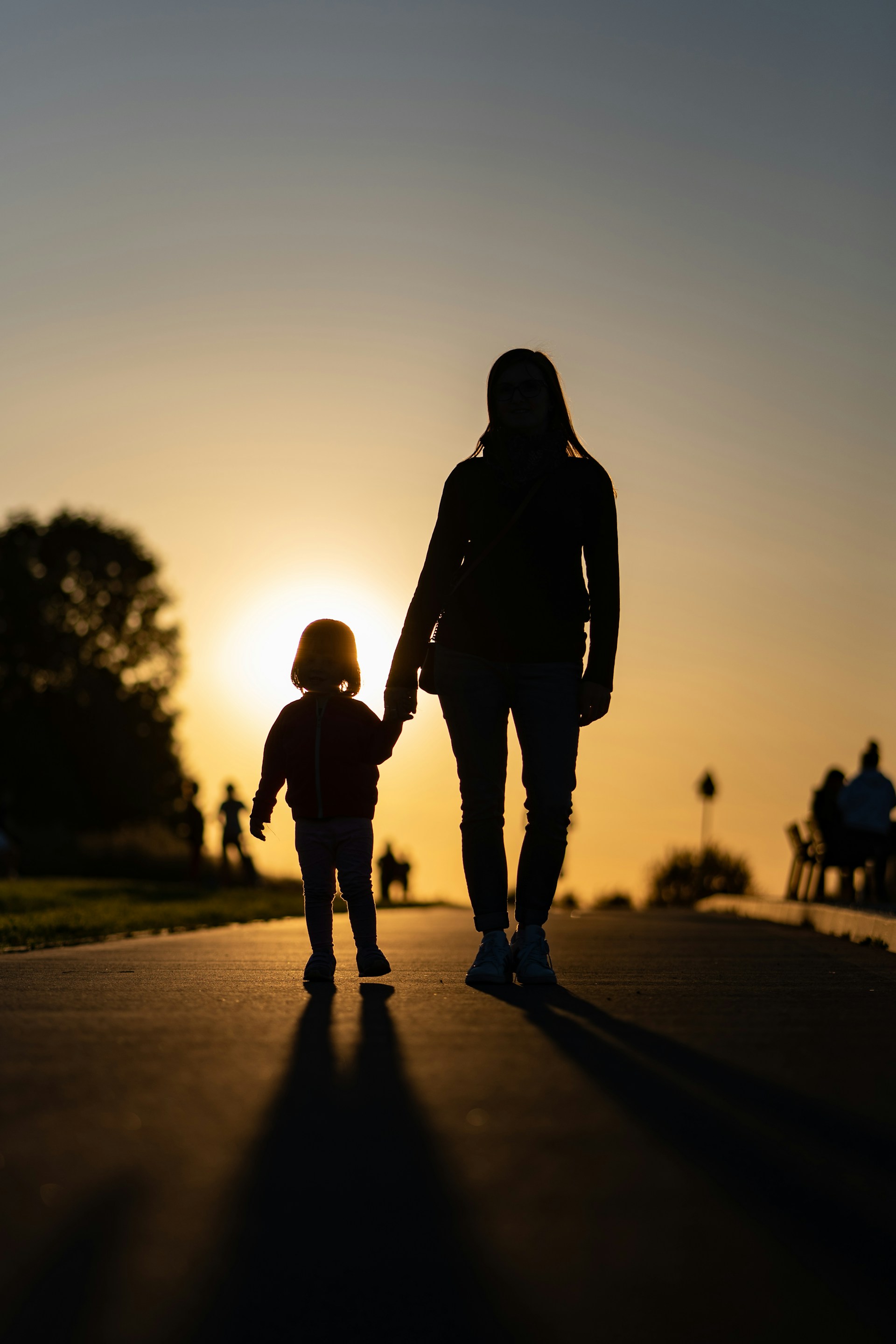 Una madre y su hija pequeña viendo la puesta de sol | Fuente: Unsplash
