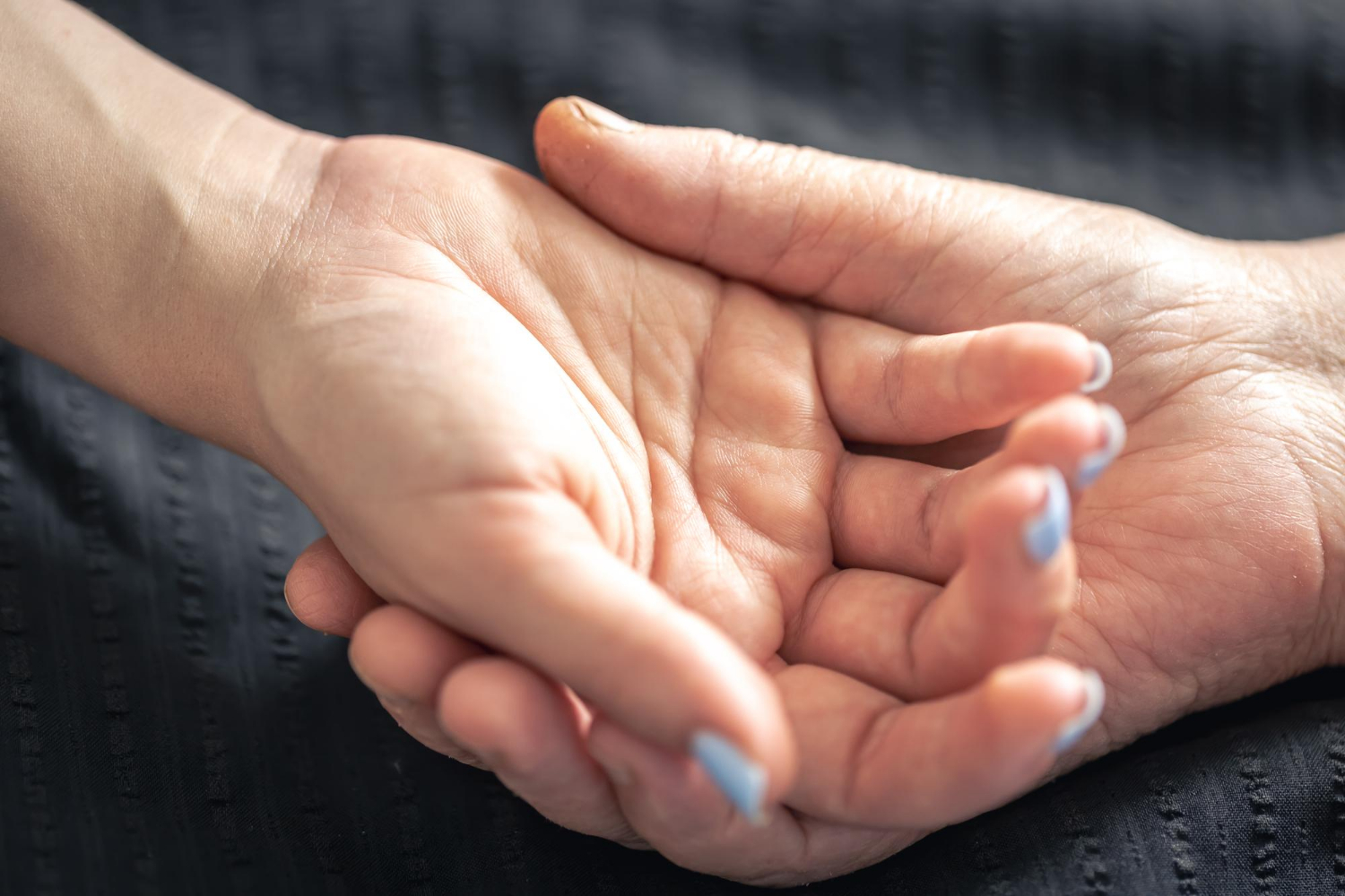 Una persona mayor tomando de la mano a una joven | Fuente: Freepik