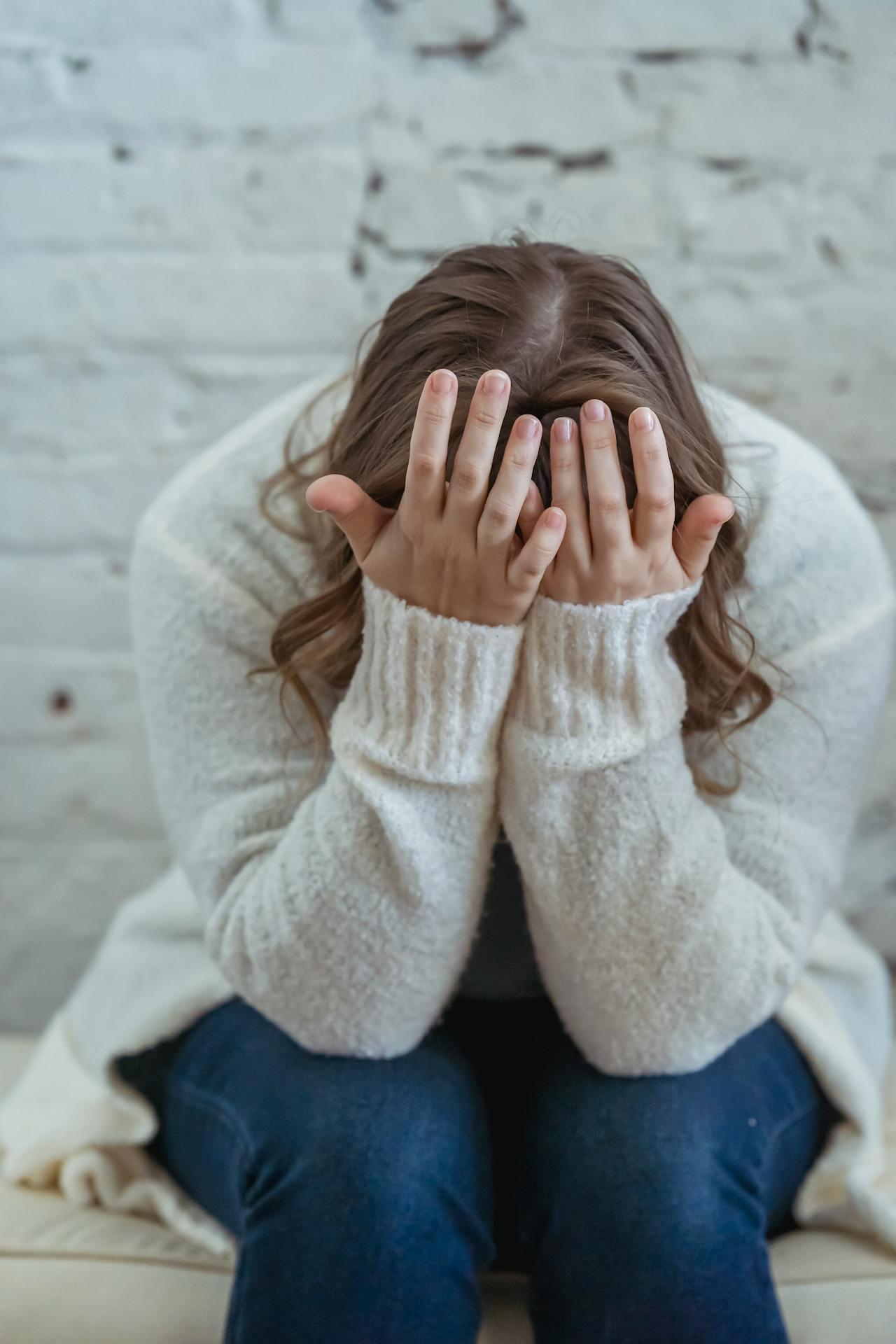 Una mujer triste sentada en el sofá | Fuente: Pexels