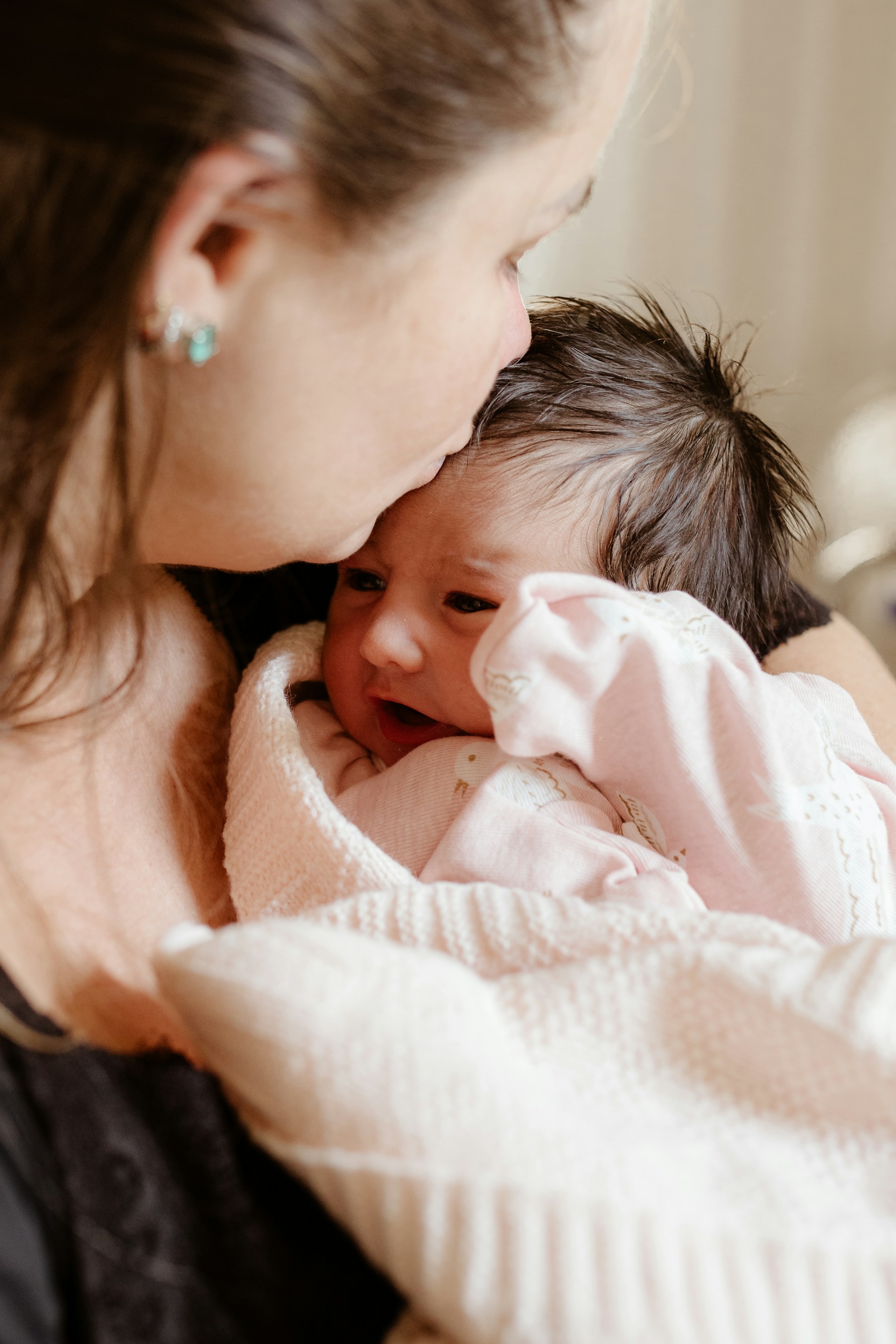 Una madre besando a su bebé | Fuente: Unsplash