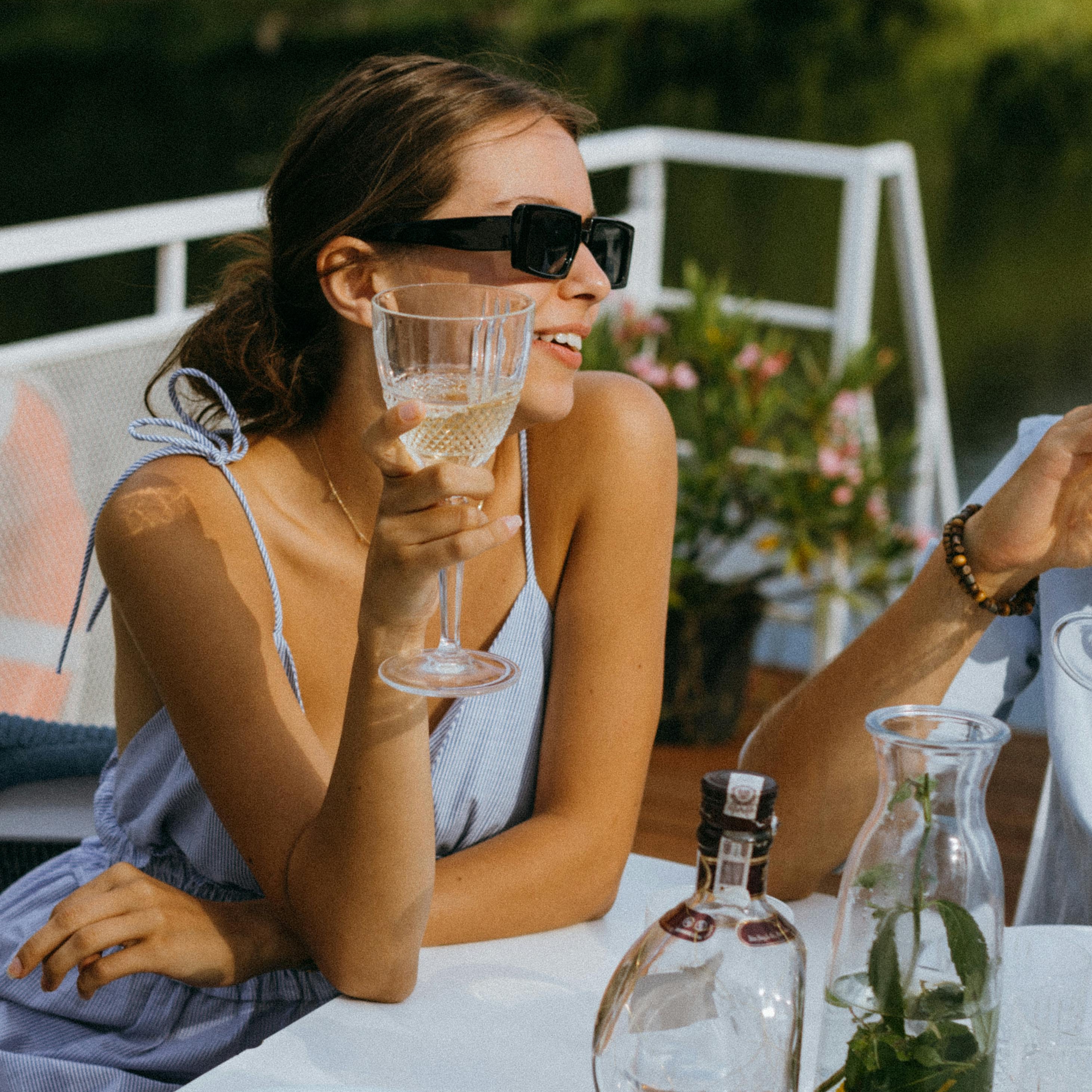 Una mujer a bordo de un yate levanta una copa en señal de celebración | Fuente: Pexels