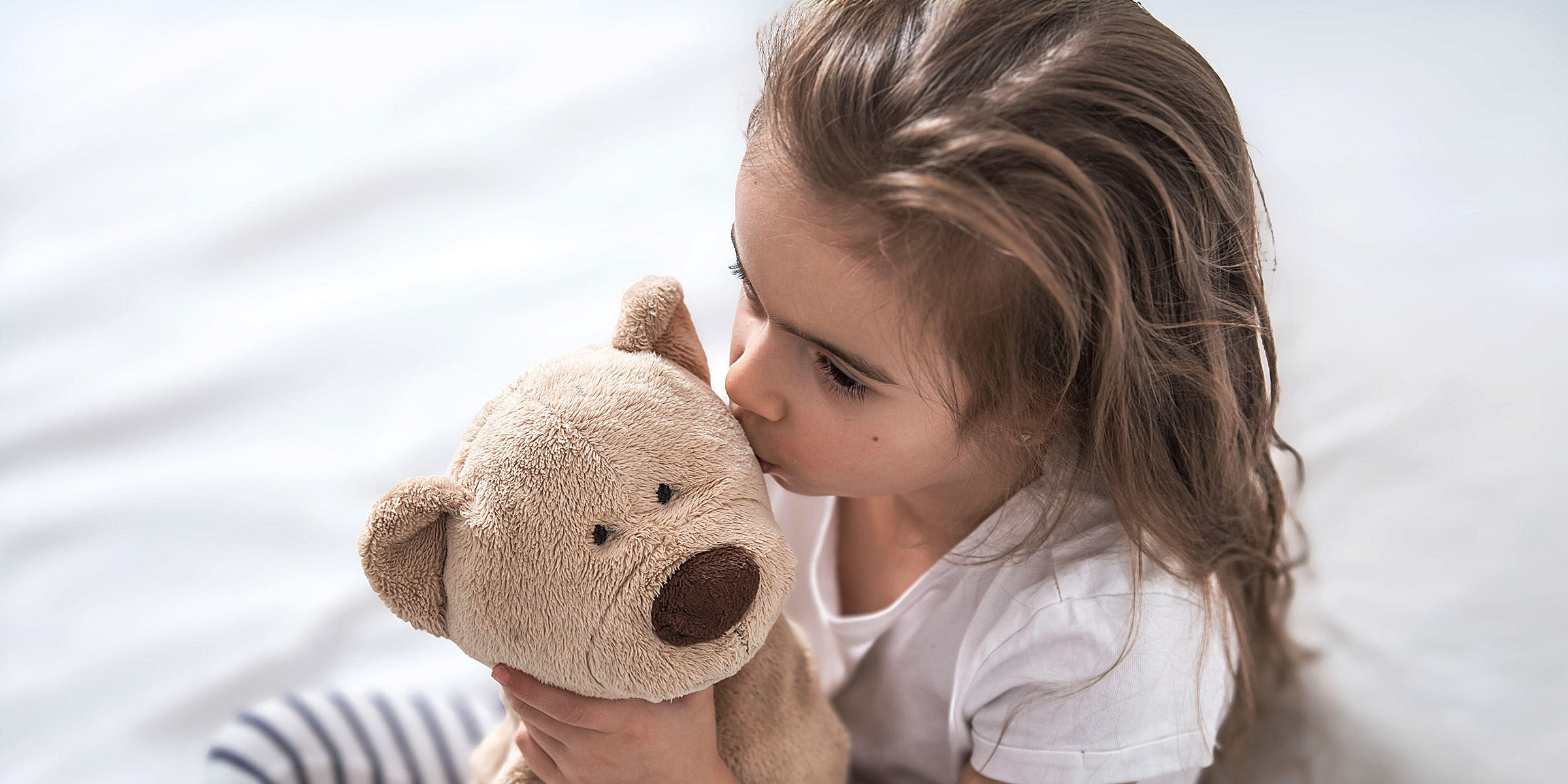Una niña con su osito de peluche | Fuente: Freepik