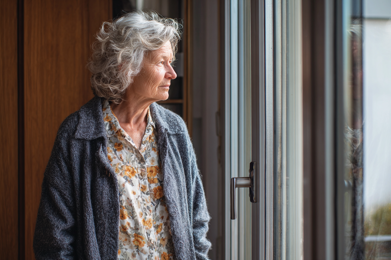 Una mujer junto a una ventana | Fuente: Midjourney