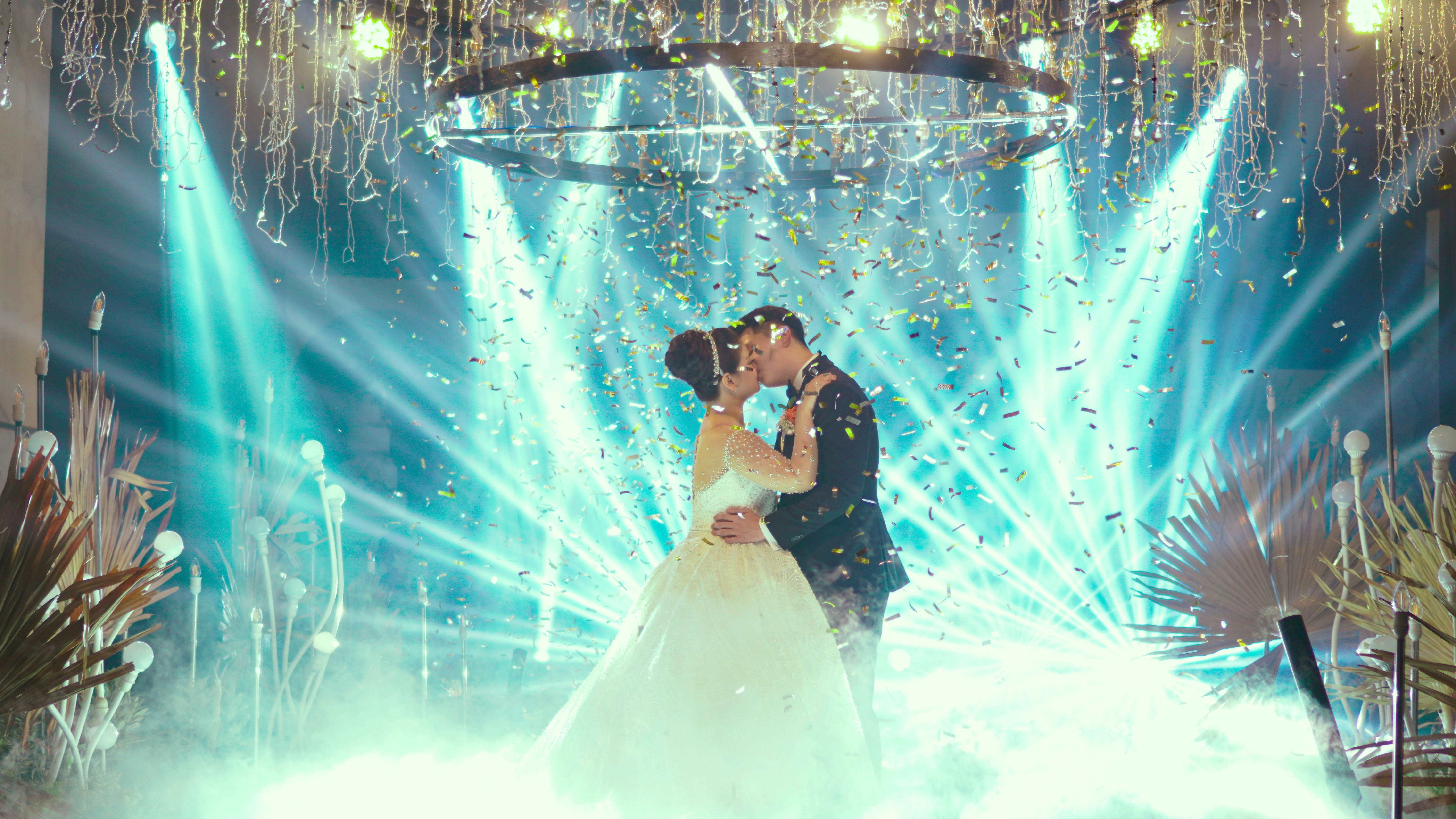 Recién casados besándose bajo la luz azul | Fuente: Unsplash