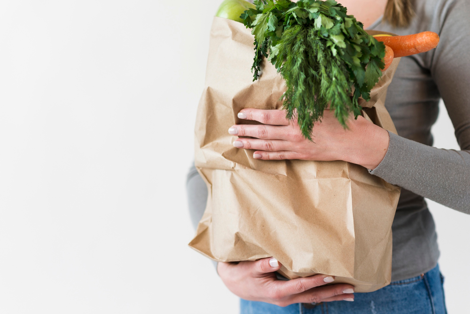 Una mujer con una bolsa de la compra en la mano | Fuente: Freepik