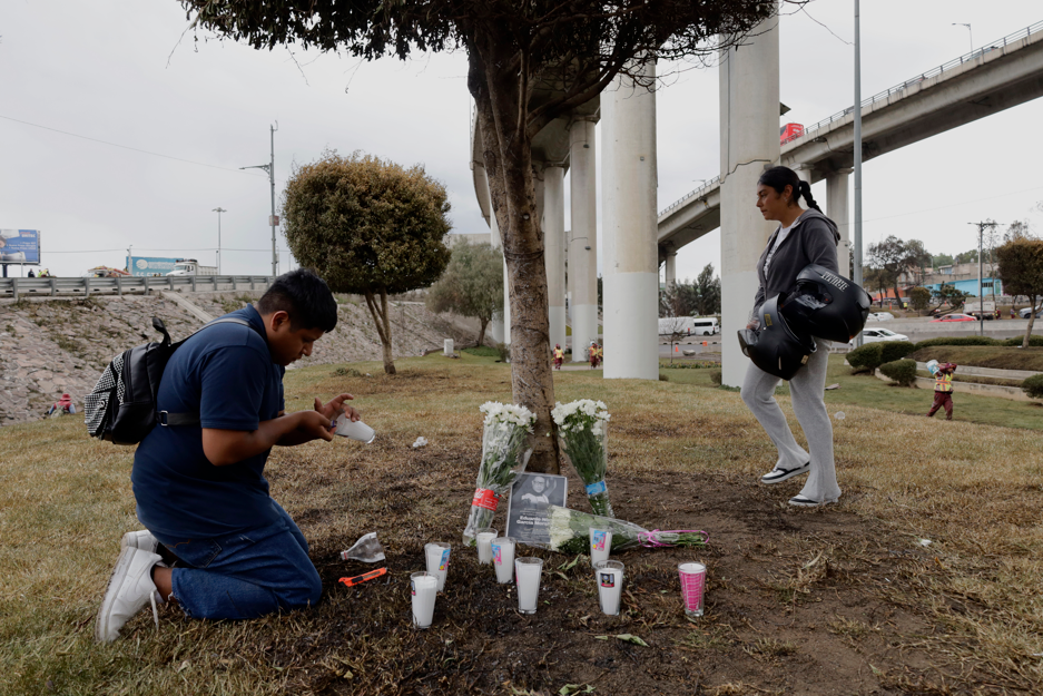 Jóvenes colocan una corona de flores y velas en memoria de Eduardo Noe García Morales, profesor de secundaria, tras su muerte en la explosión de un oleoducto en el Puente Concordia en Iztapalapa, Ciudad de México, el 10 de septiembre de 2025. | Fuente: Getty Images.