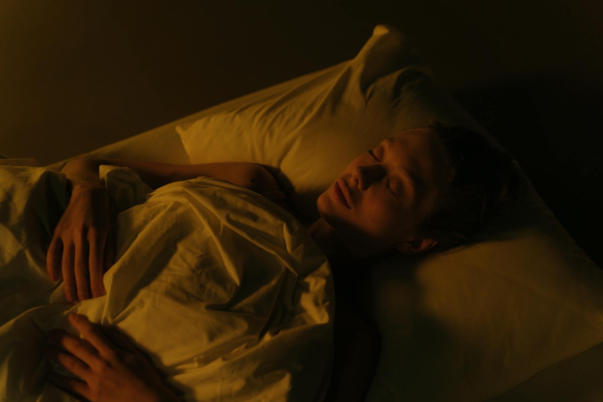 Una mujer tumbada en la cama por la noche | Fuente: Pexels