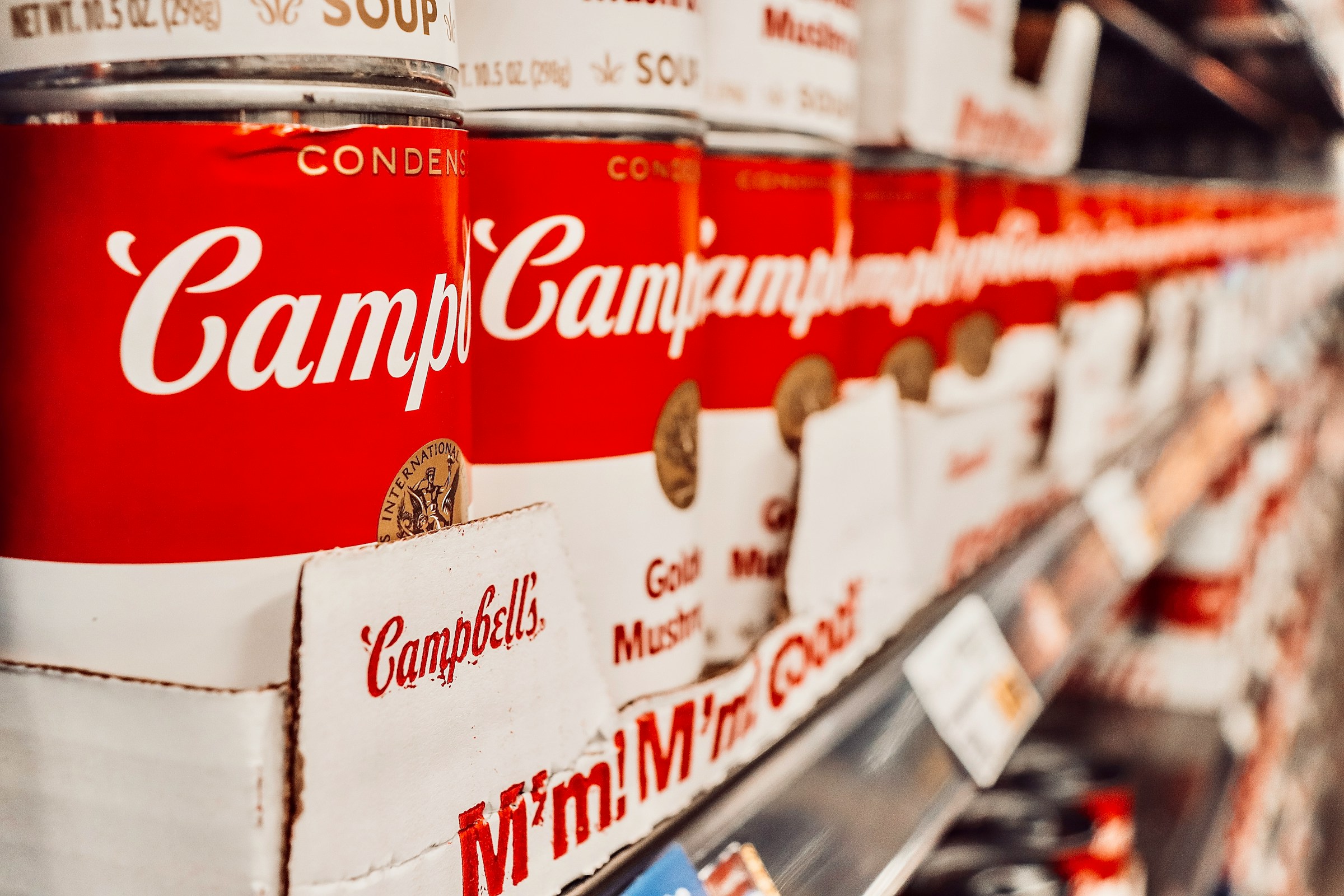 Latas de sopa apiladas en la estantería de un supermercado | Fuente: Unsplash