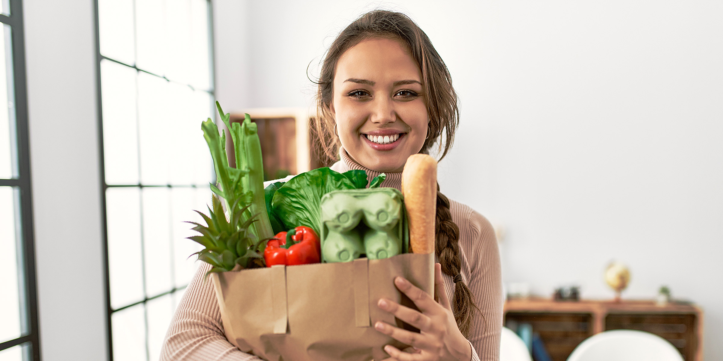 Una mujer con una bolsa de las compras en la mano | Fuente: Shutterstock