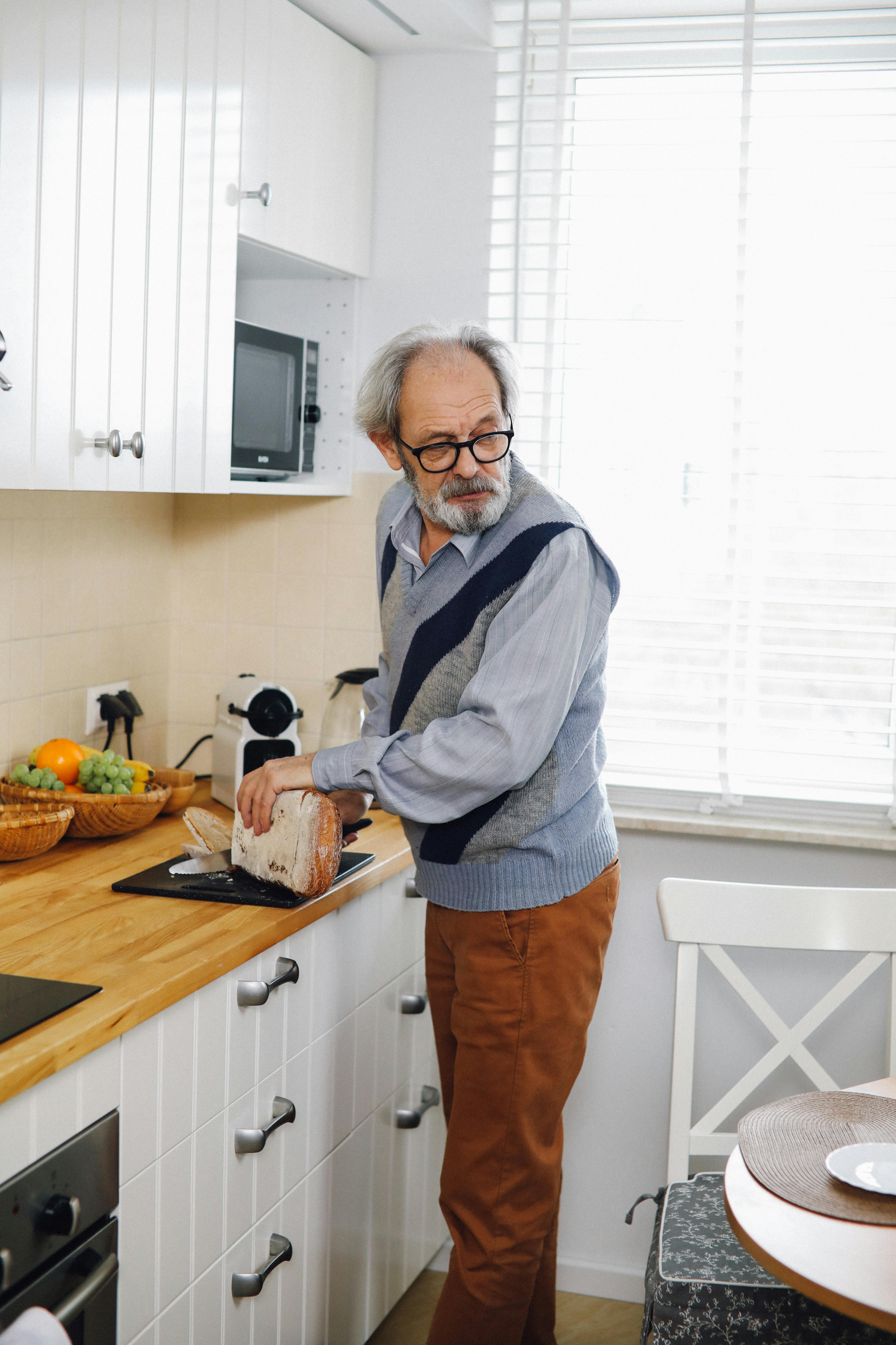Un hombre mayor de pie en la cocina | Fuente: Pexels