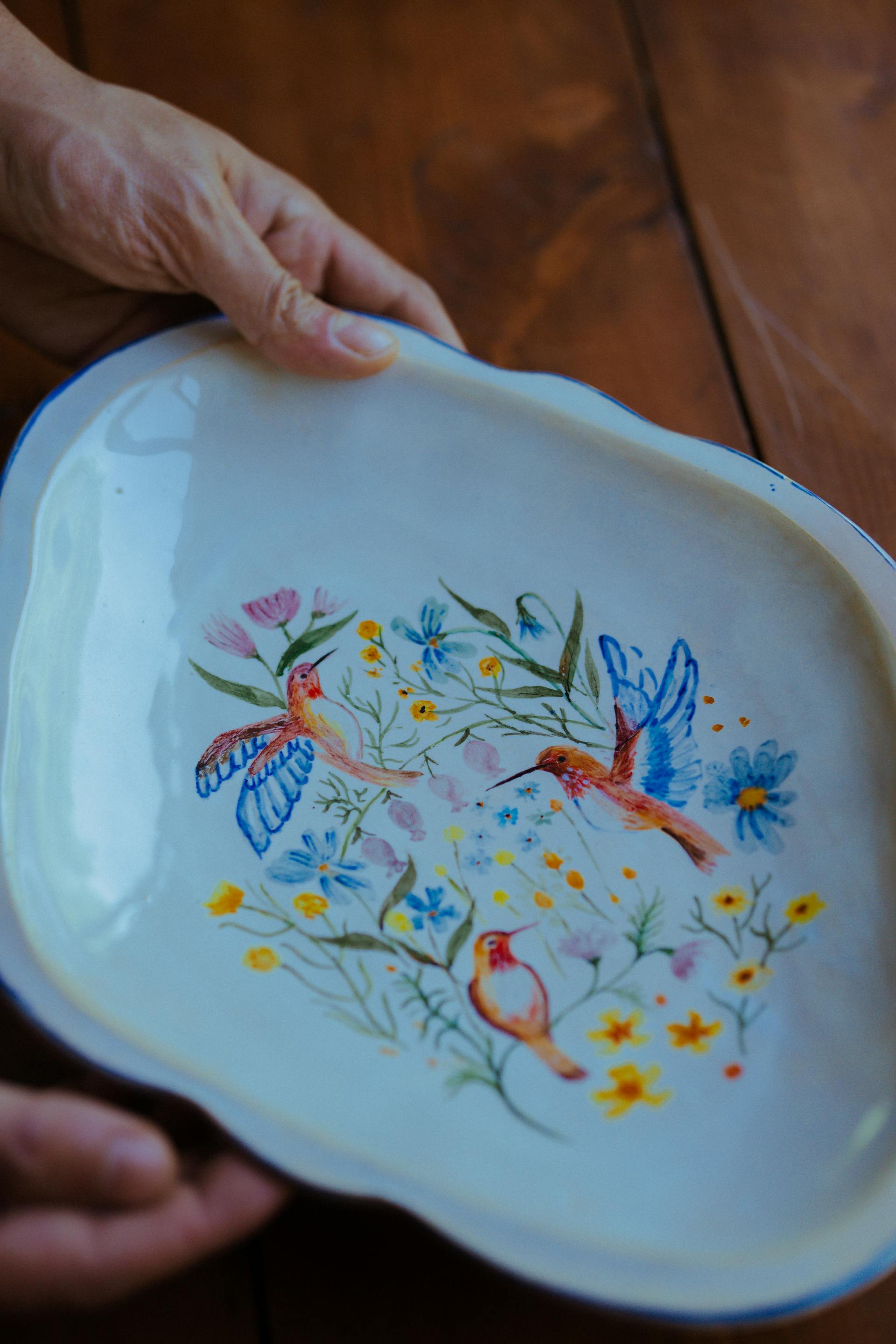 Una mujer sostiene un plato de cerámica pintado a mano | Fuente: Pexels